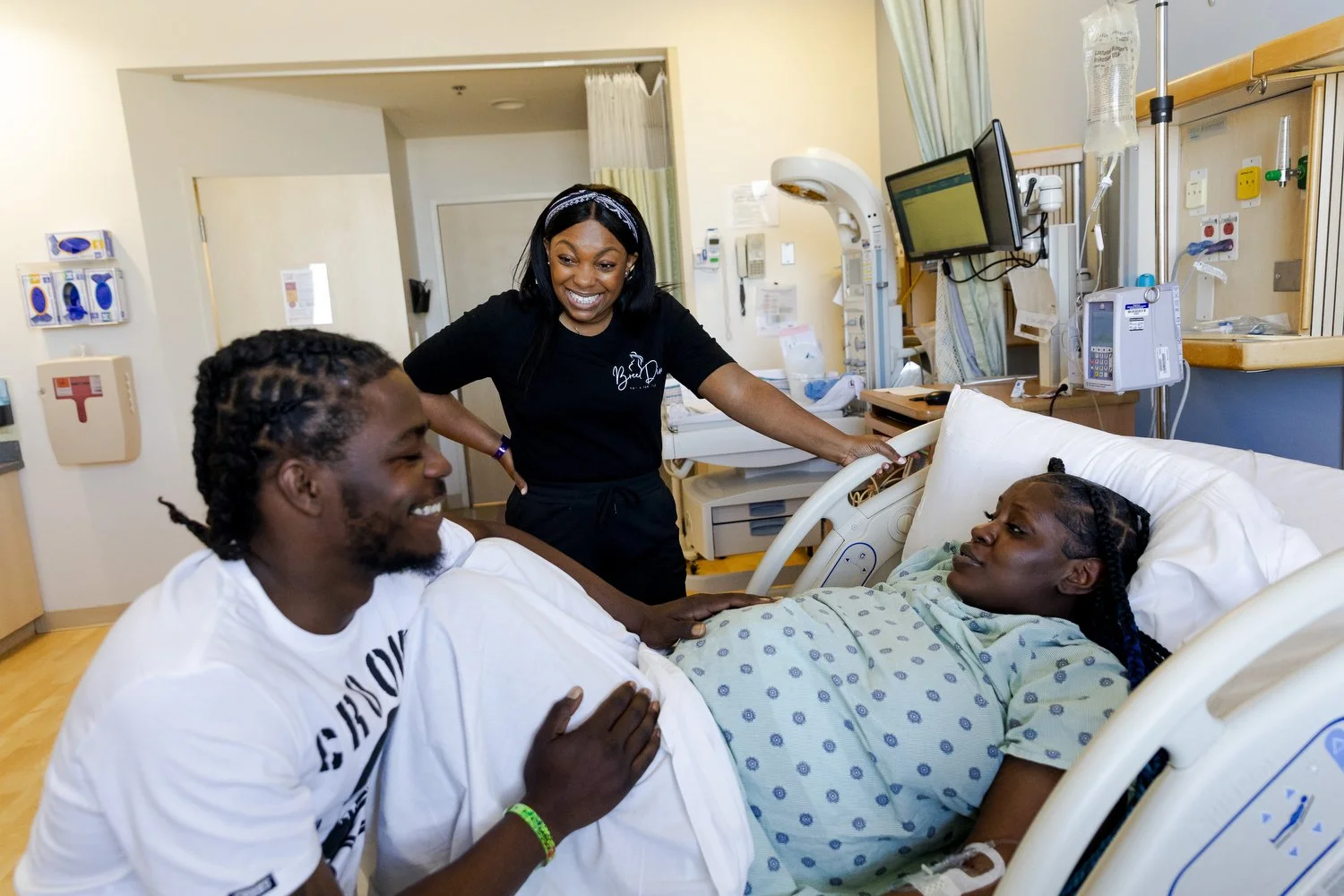 Bree Stallings, certified doula, at postpartum visit, Detroit, MI,  assisting a mother during birth