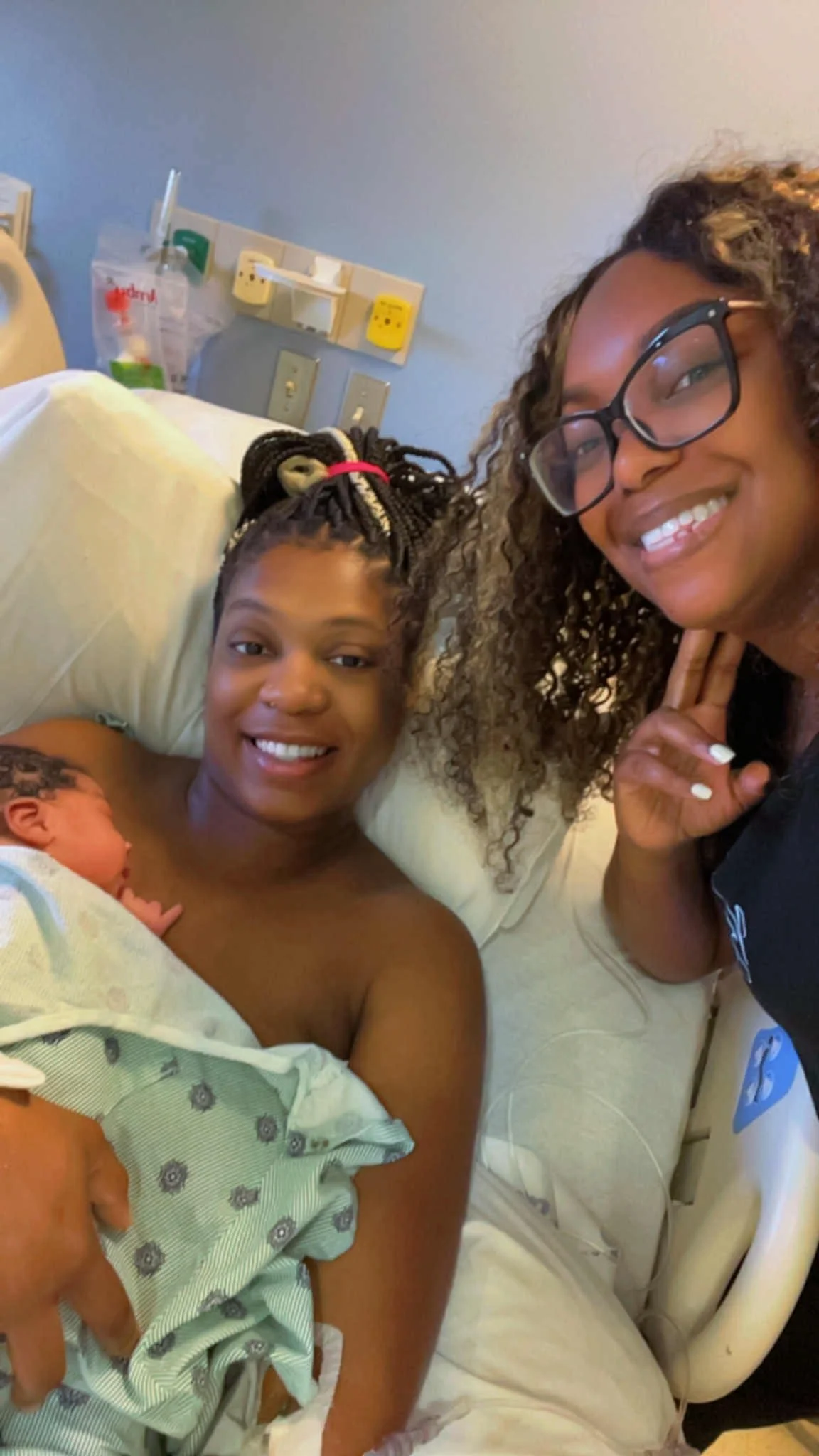 Bree Stallings, certified doula, at postpartum visit, Detroit, MI, assisting a mother during birth