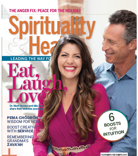 Cover of a magazine featuring a smiling woman with long brown hair wearing a pink top, standing next to an older man in a blue shirt. The magazine title is "Spirituality & Health," with headlines about peace, wellness, and intuition.