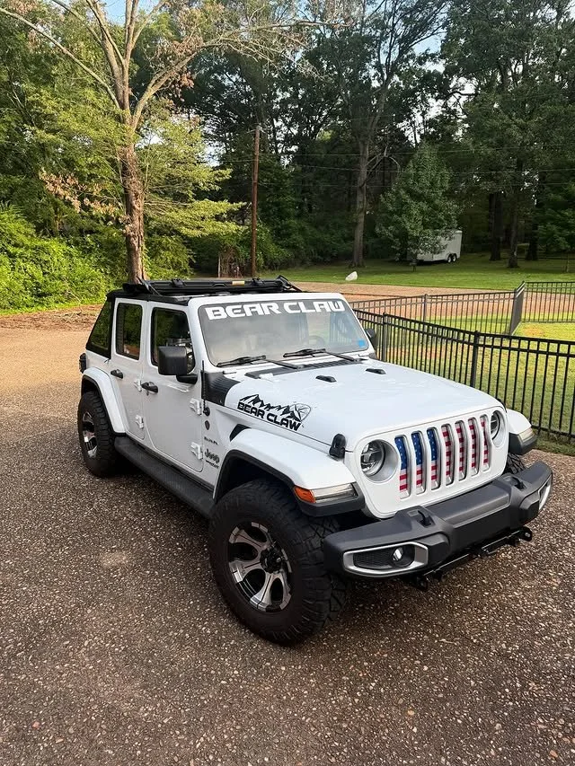White Bear Claw branded Jeep parked outdoors in the woods