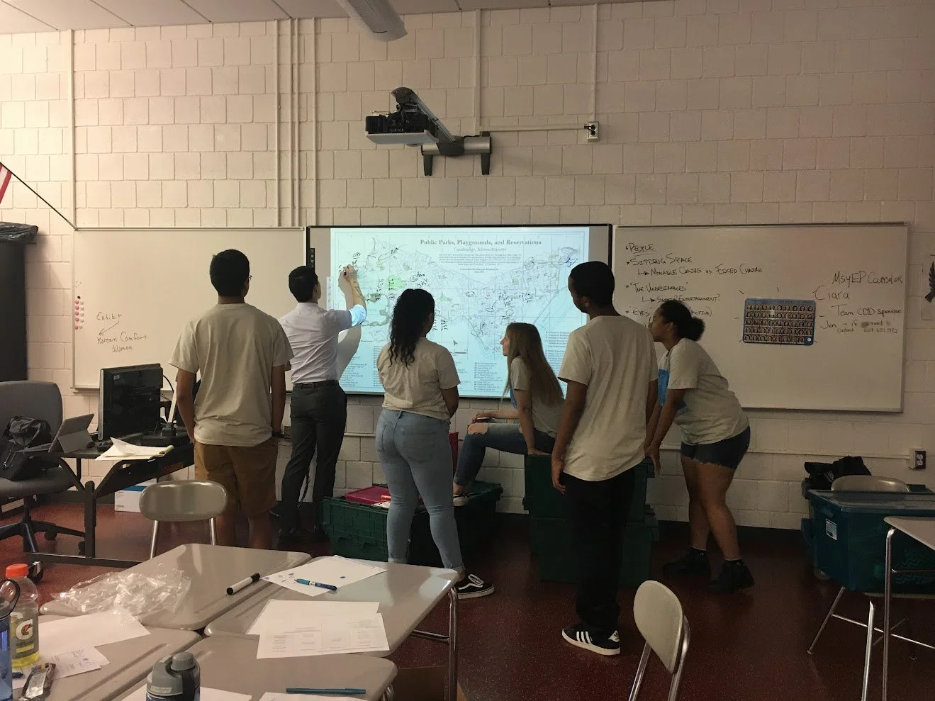 Design Charette with young people and city planner. People drawing on a map that is up on a white board in a classroom.