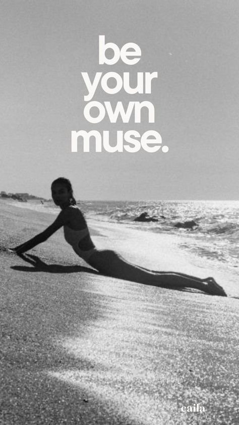 A black and white photo of a person on a beach doing a pose that makes them look like a mermaid with a long tail, with the text 'be your own muse' above.