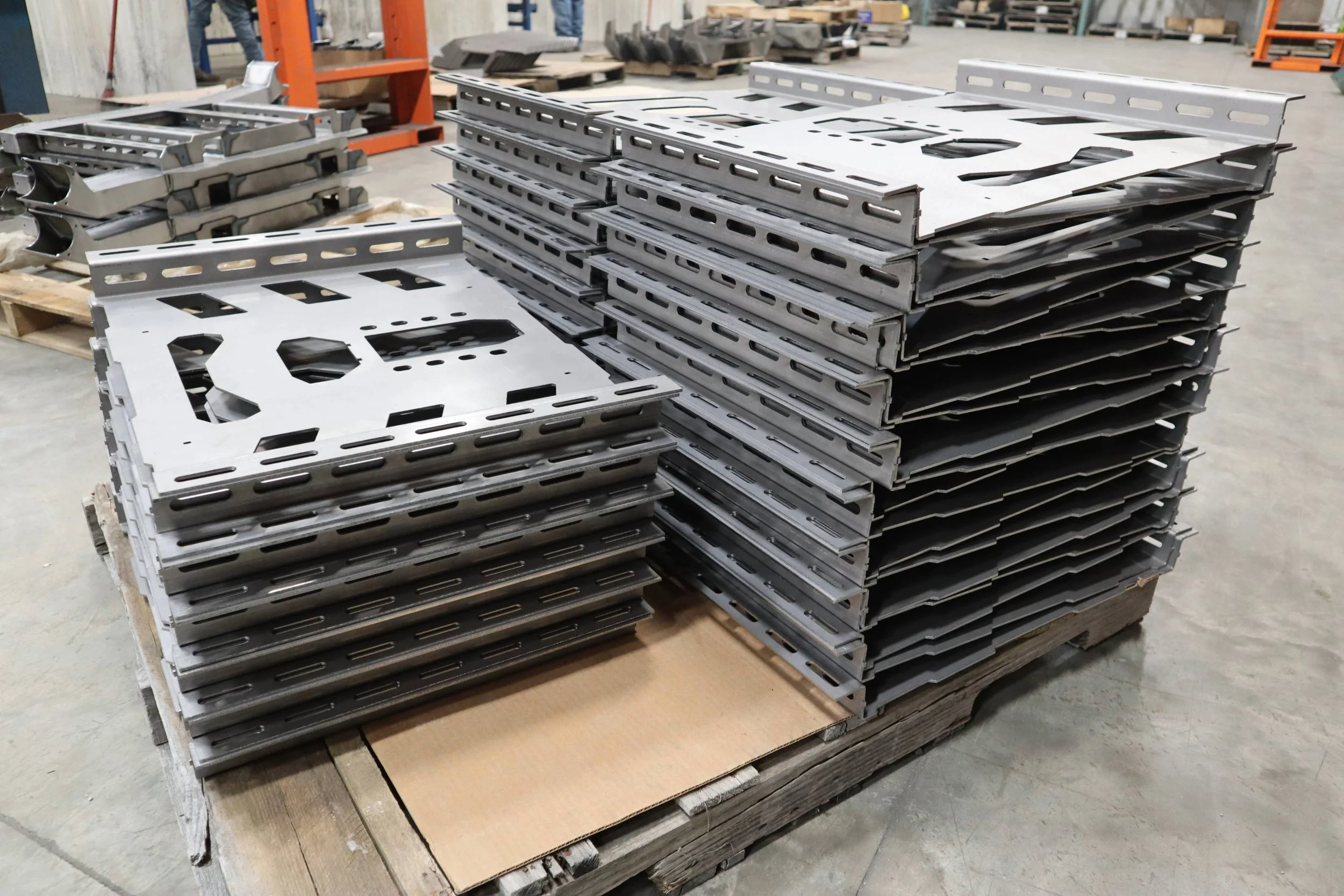Stacked metal parts on a wooden pallet at a metal fabrication facility