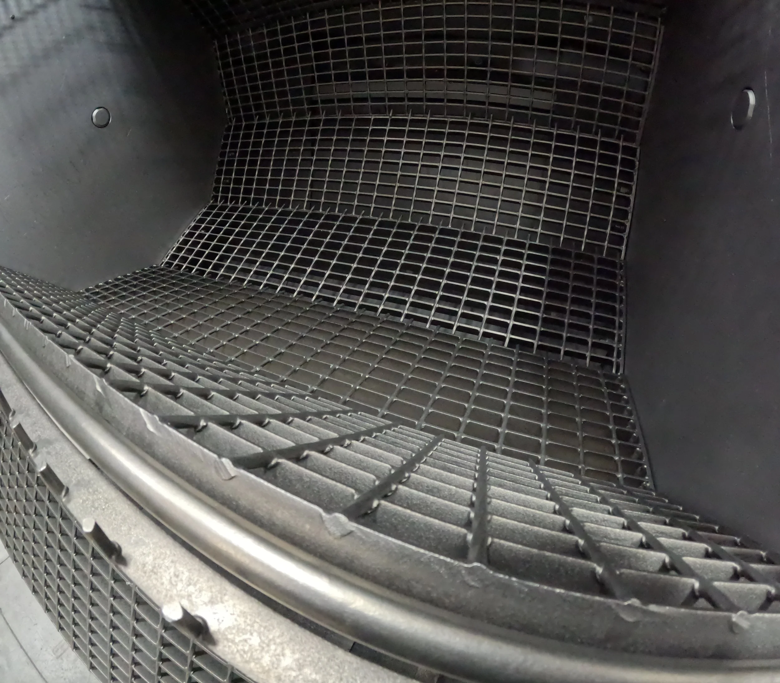Inside view of a black oven or microwave with a metal grate rack