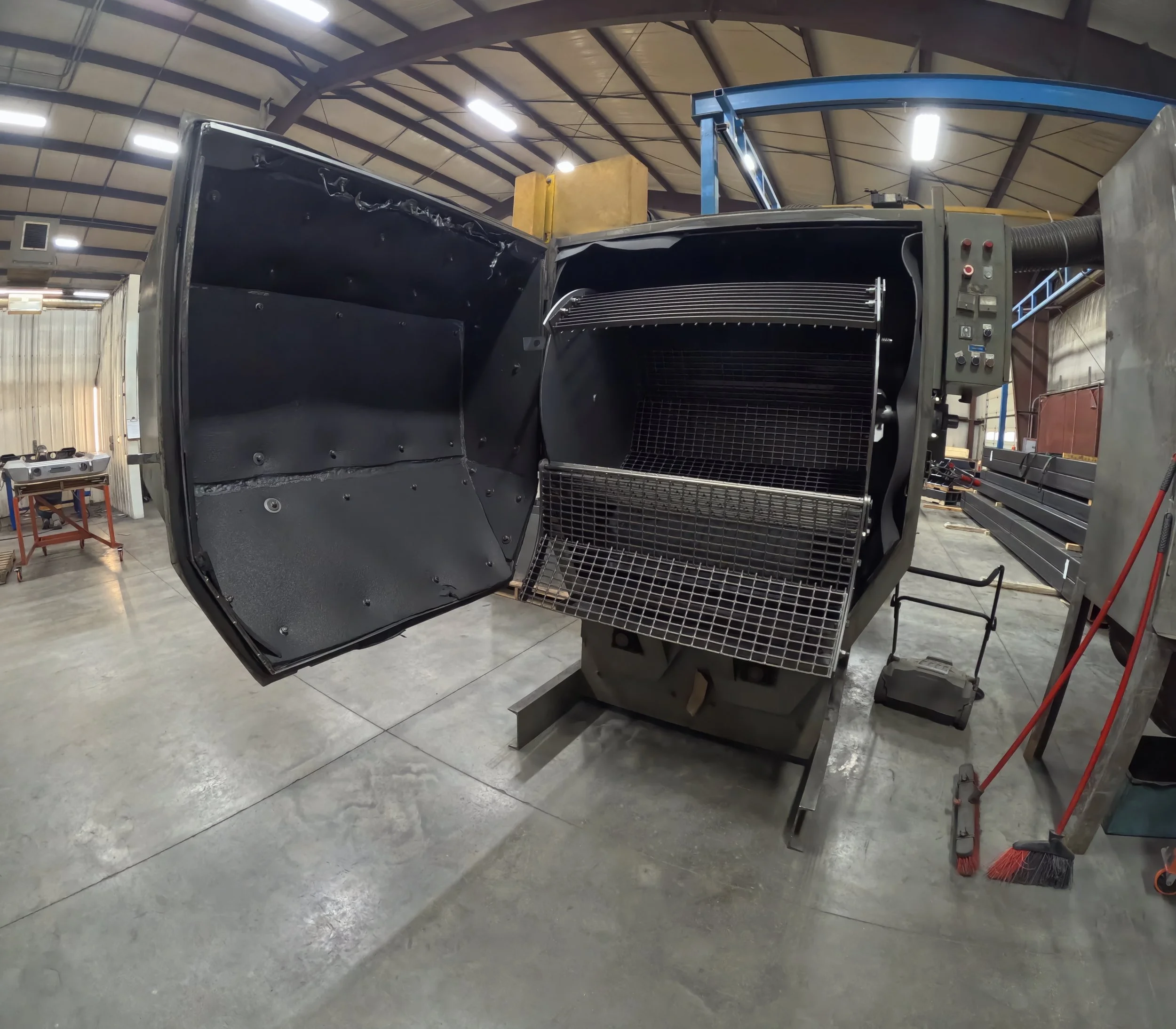The interior of a large industrial oven or furnace with an open door, indicating a manufacturing or industrial environment.