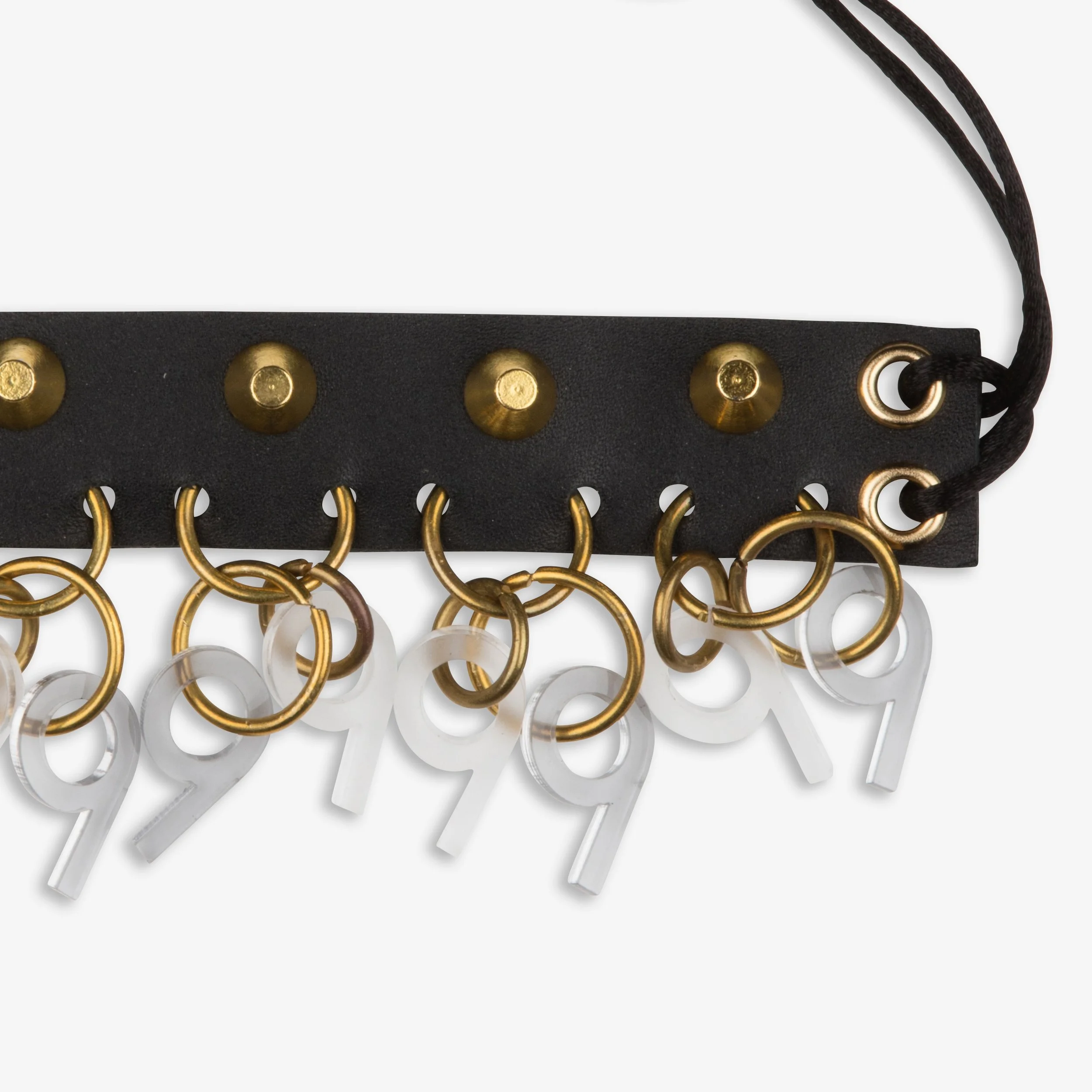 Black leather keychain with gold eyelets and rings, attached to numbered acrylic tags in white and gold.