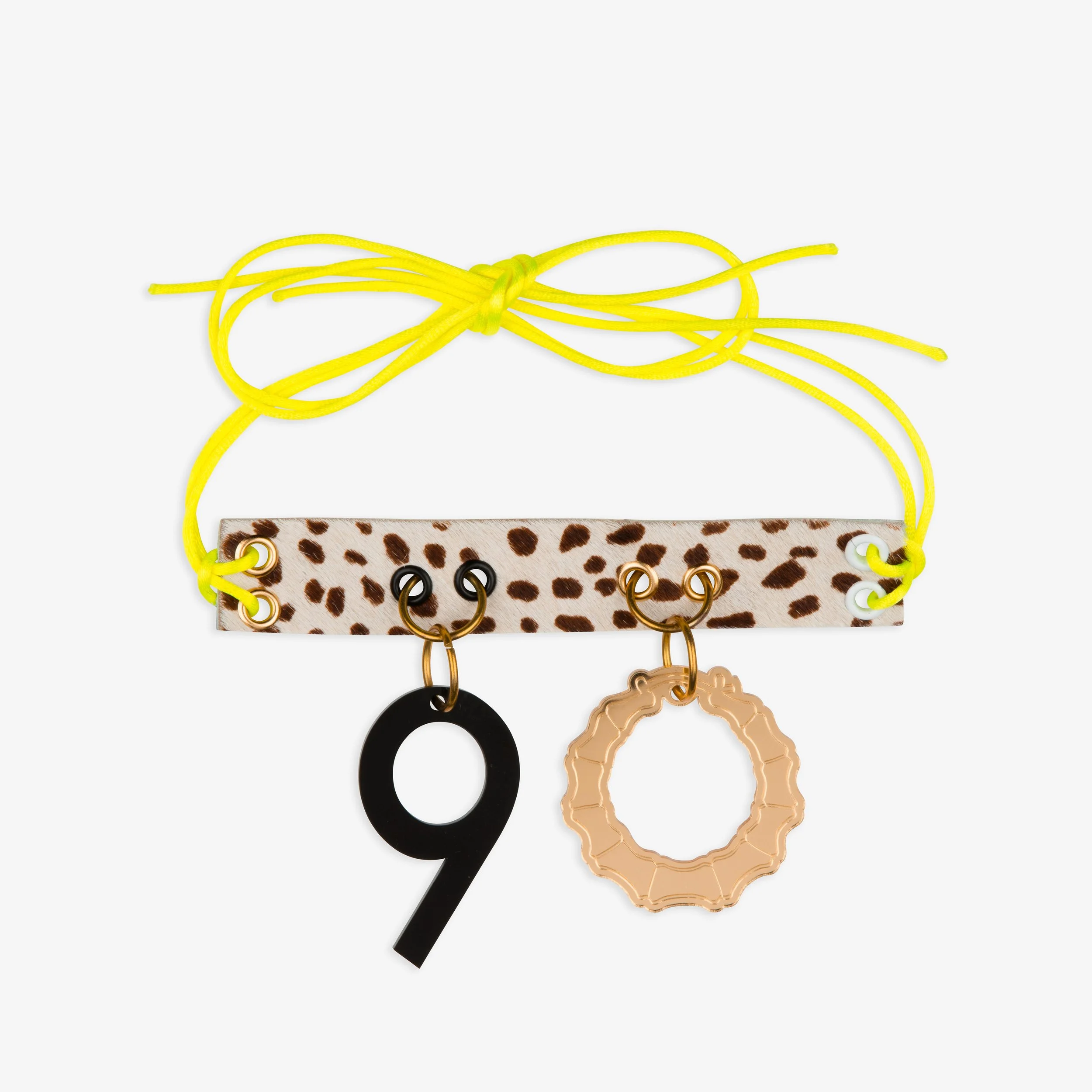 Leopard print fabric holder with yellow string and number 9 and ring charms attached.