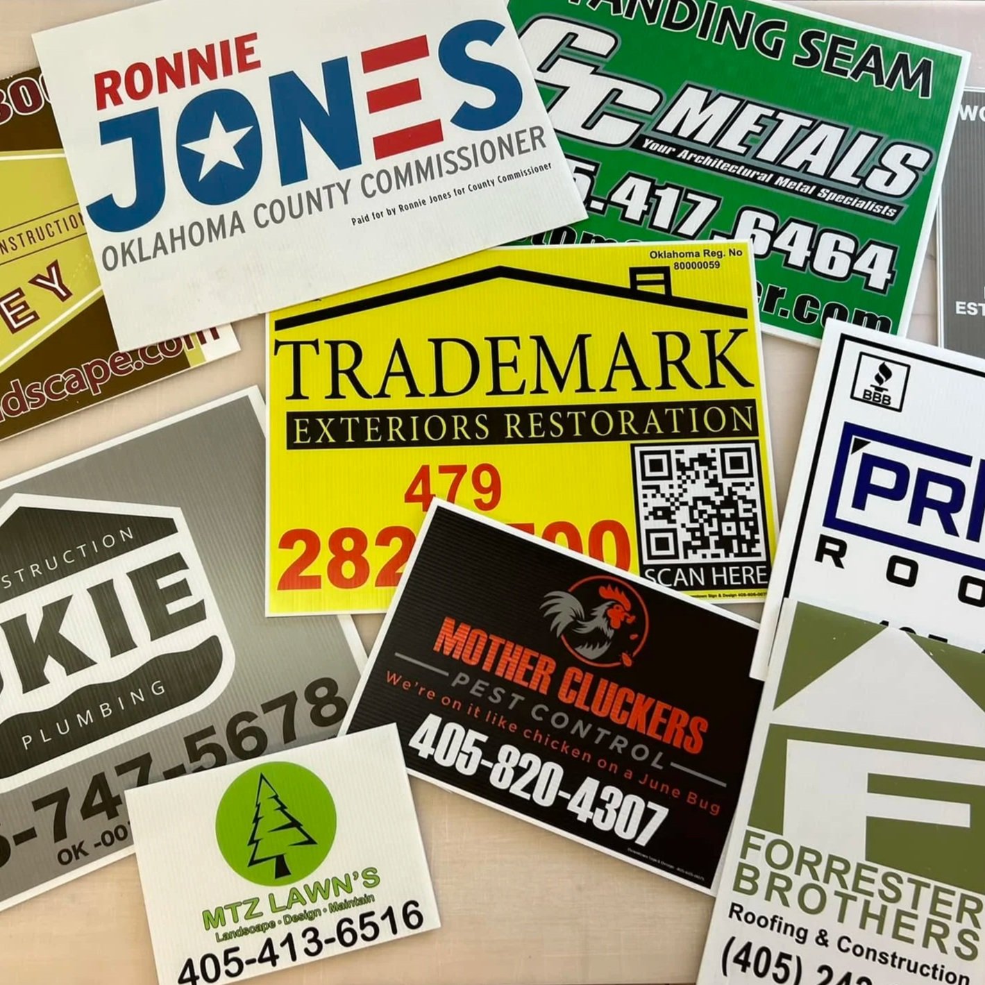 A collection of custom coroplast yard signs, including political campaign, construction, landscaping, pest control, and roofing services.