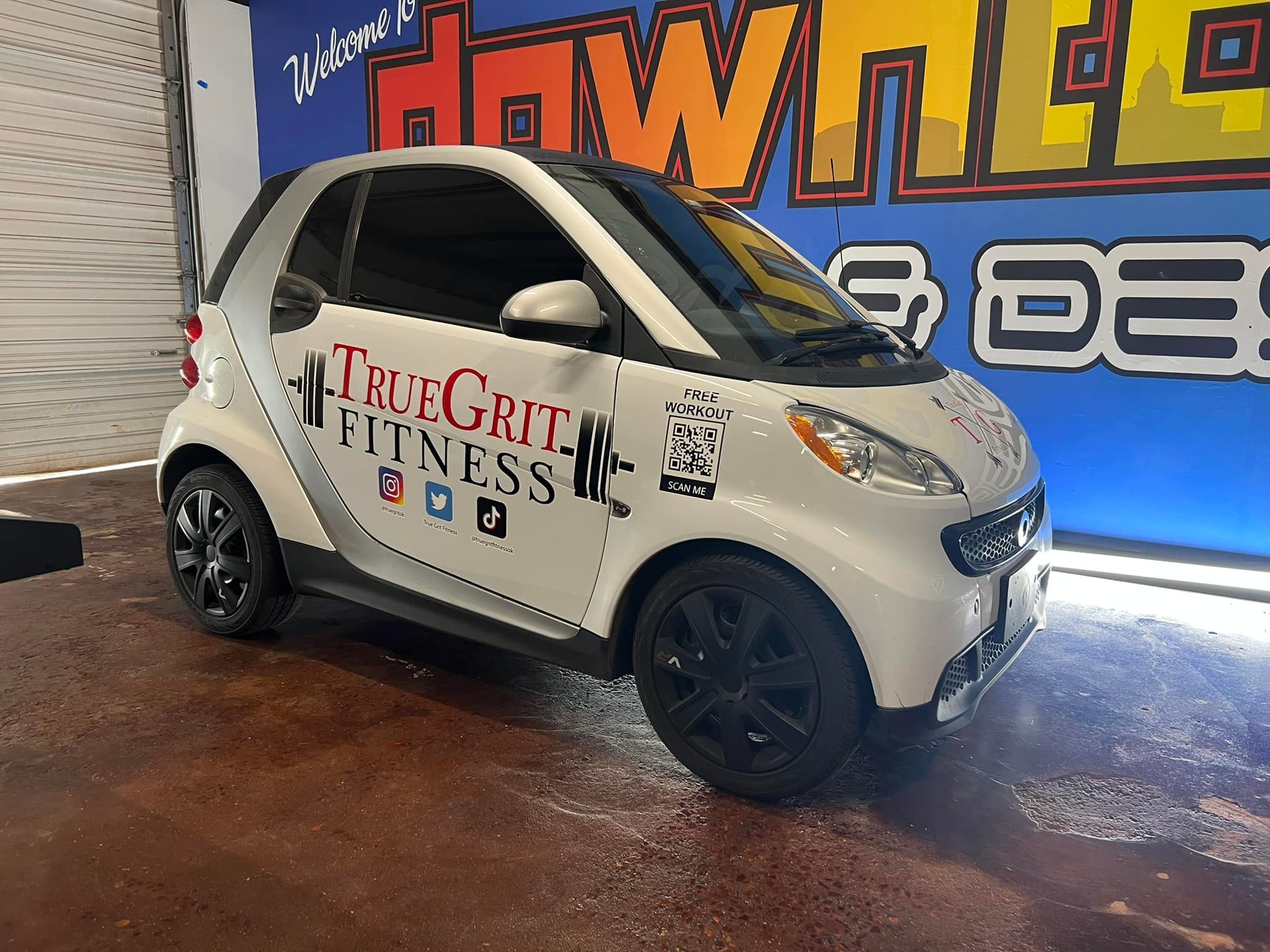 True Grit Fitness partial vehicle wrap including social media icons and a QR code