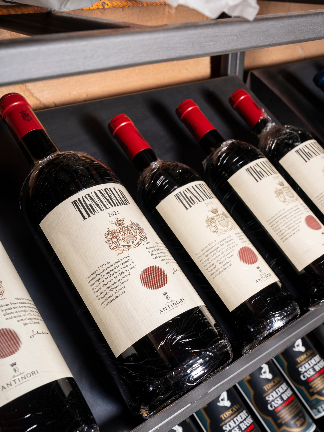 Bottiglie di vino rosso sul scaffale con etichetta 'Tignanello'.