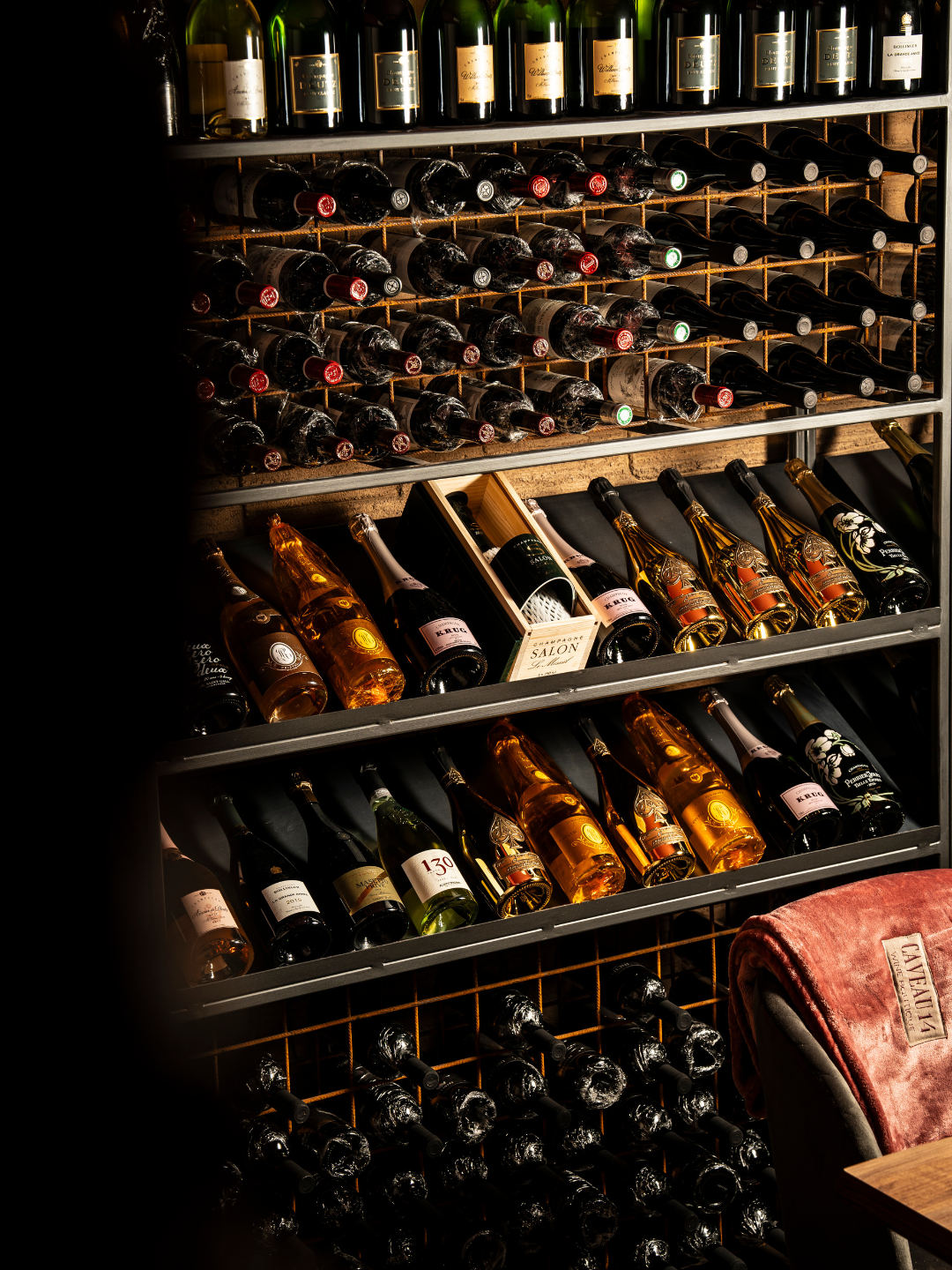 Scaffale con bottiglie di vino rosso e champagne in una enoteca