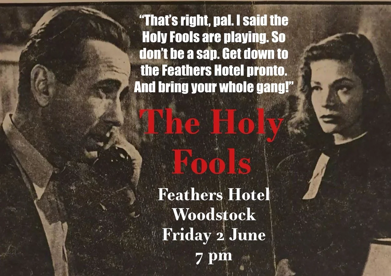 Vintage black and white poster featuring a man and a nun. The poster advertises a performance of 'The Holy Fools' at the Feathers Hotel in Woodstock on Friday, June 2, at 7 pm, with dialogue suggesting the nun is instructing someone to bring their ga