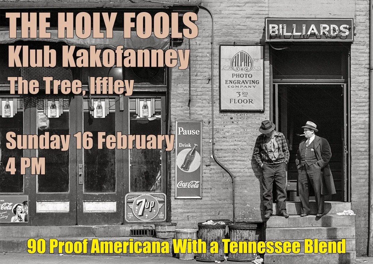 Black and white photo of two men standing outside a bar or pub, one with a hat and cigarette, the other with a hat and leaning in. There are signs for billiards, a photo engraving company, Coca-Cola, and 7 Up visible on the building. Text overlay ann