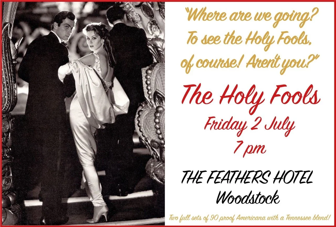 Black and white vintage photo of a man and woman dressed formally, standing near ornate carriages, with the woman holding a coat. Overlaid on the right side is colorful event information about a Holy Fools event at The Feathers Hotel in Woodstock, sc