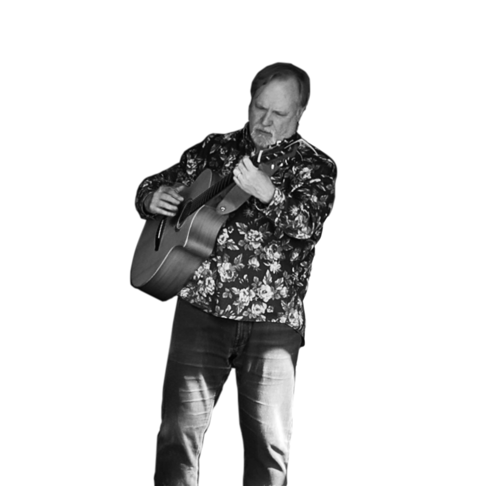 A man with a beard and floral shirt playing an acoustic guitar.