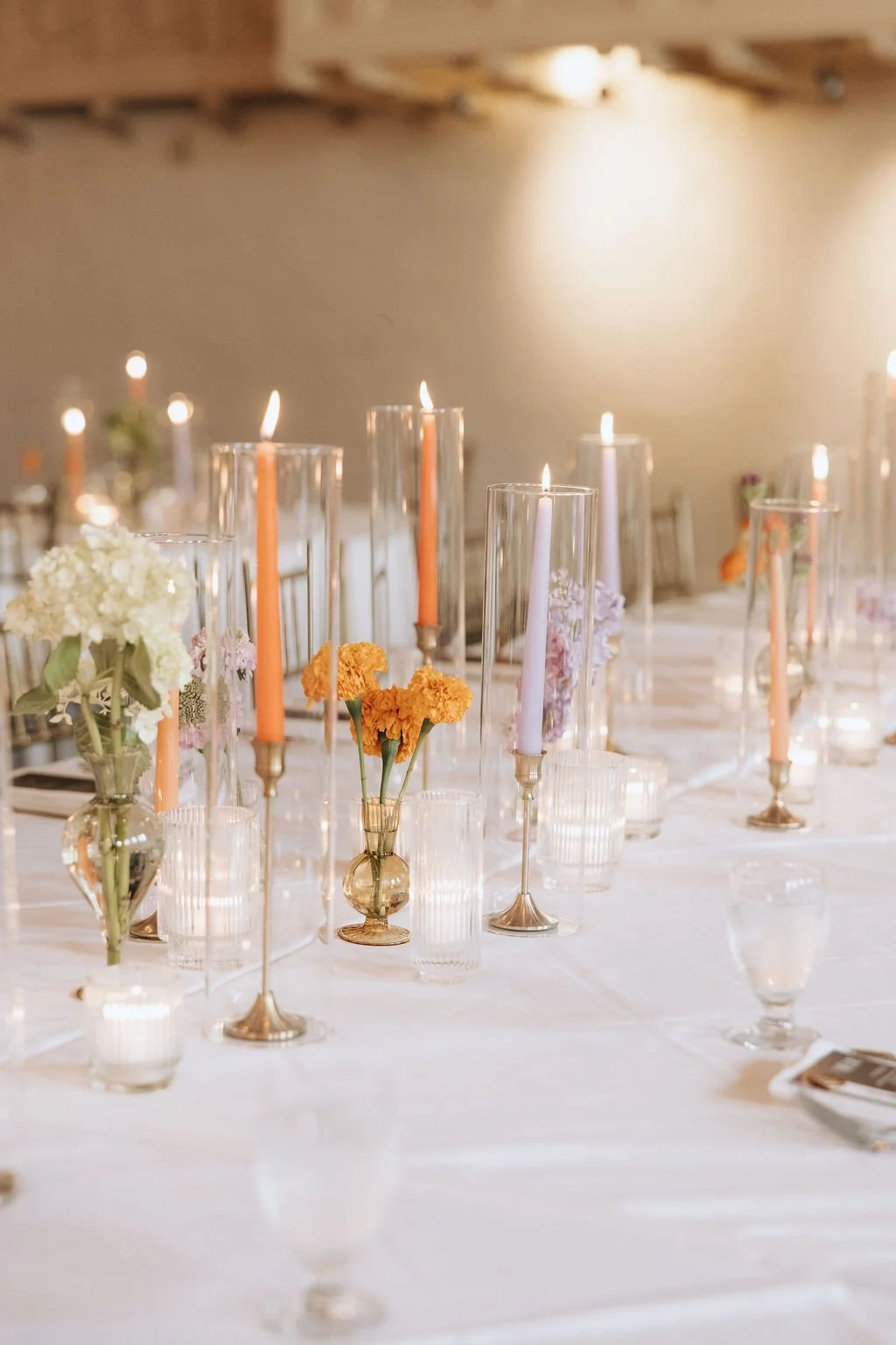 Decorative table setting with candles and flowers for a celebration or event.