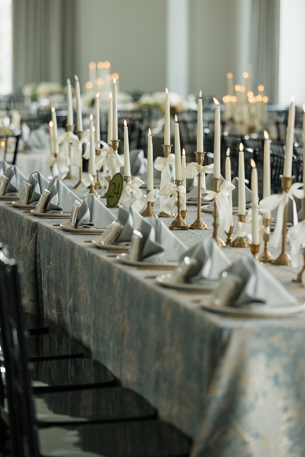 Elegant banquet table with white napkins, candles, and floral decorations.