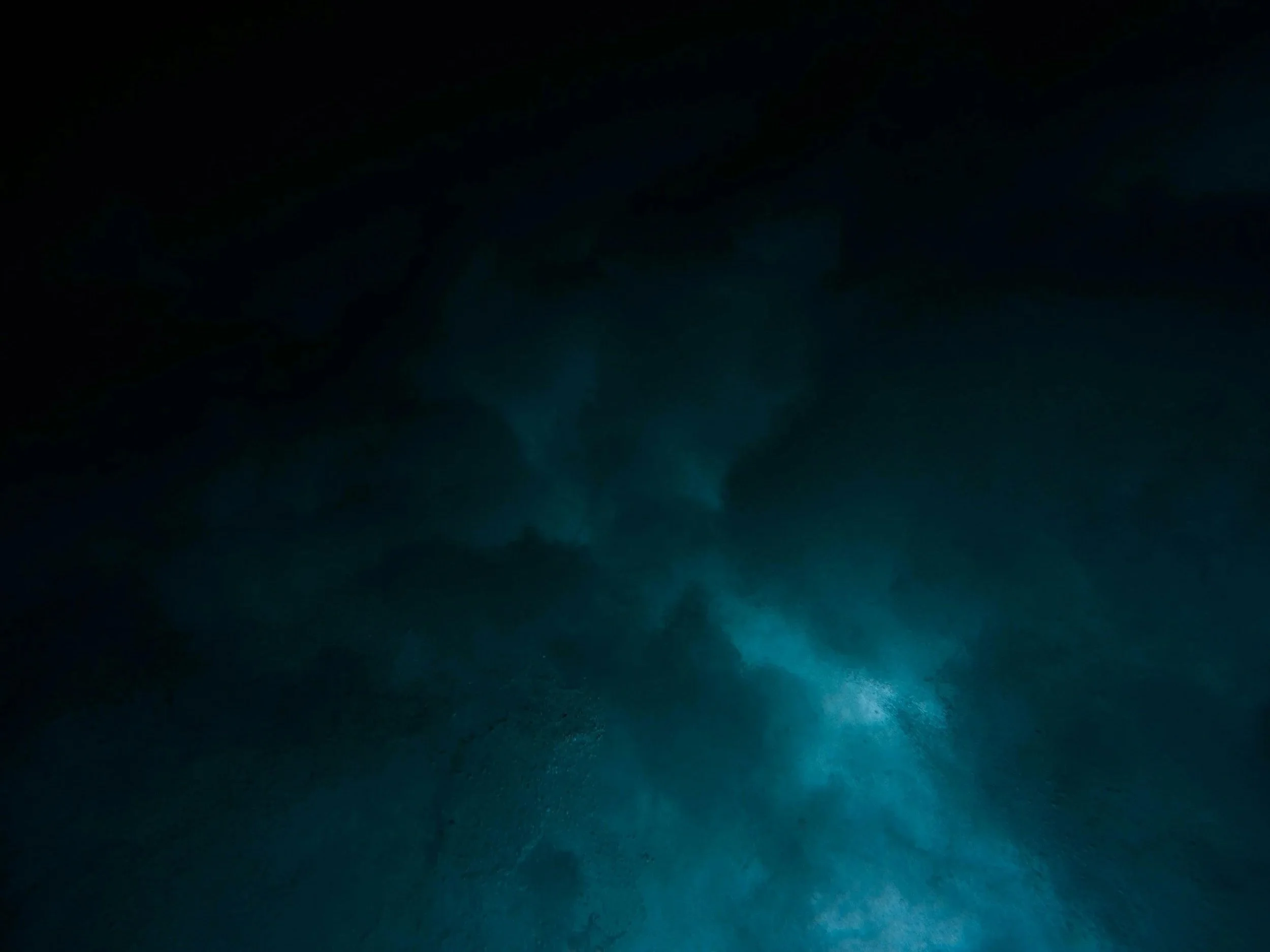 Dark underwater scene with rays of light filtering through the water