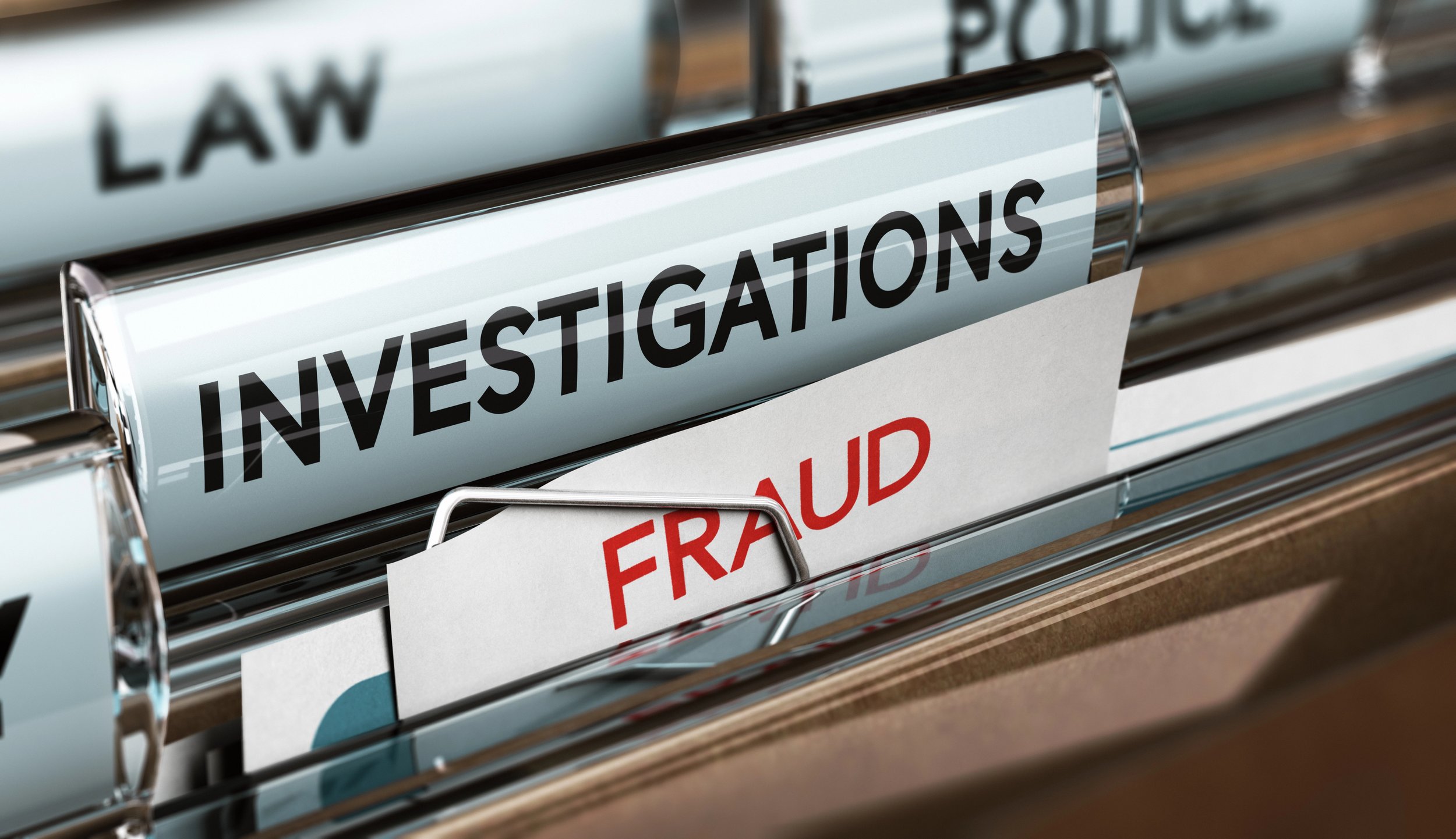 File folder with labels reading 'INVESTIGATIONS' and 'FRAUD' in an office drawer.