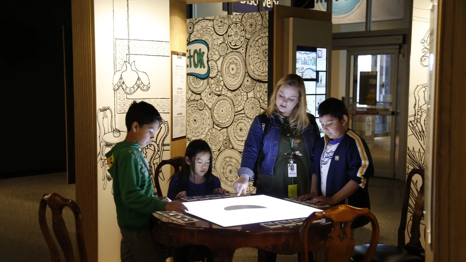 A group of kids interacts with a museum exhibit.
