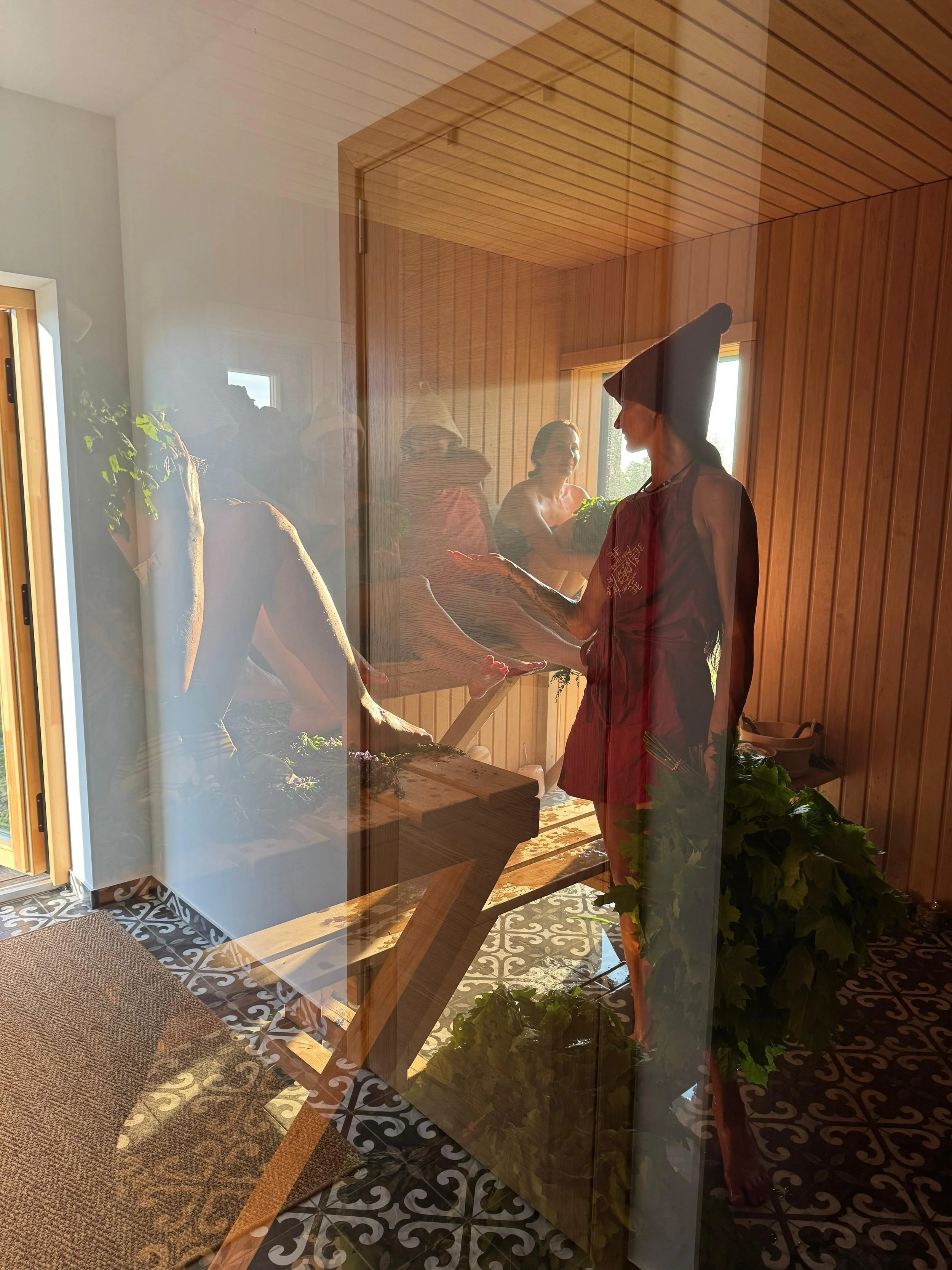 People taking a foot bath in a wooden sauna, with sunlight coming through the window.