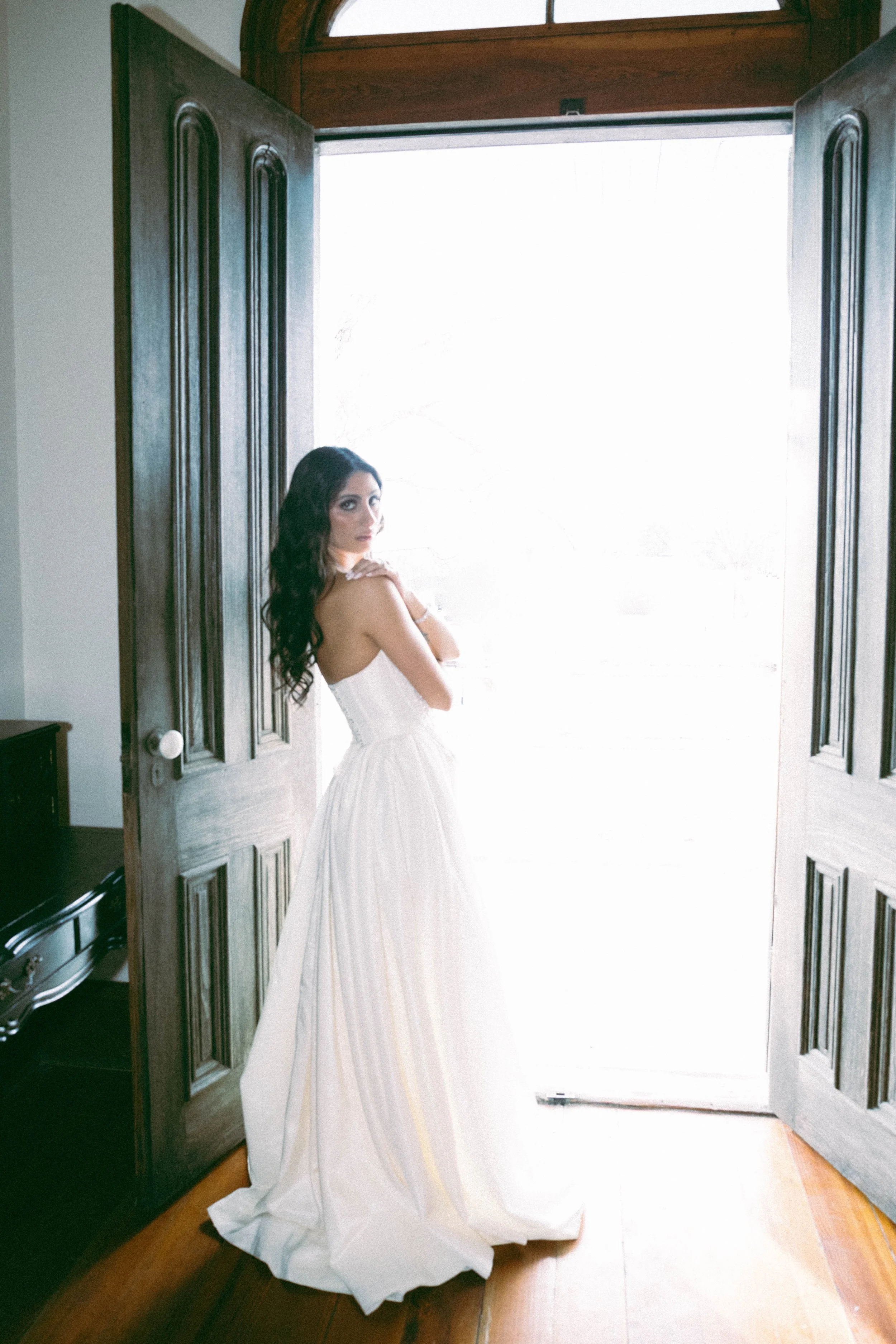 artistic film wedding photography of a bride's portrait in a historical estate venue. The image uses dramatic flash to highlight the soulful and elegant atmosphere