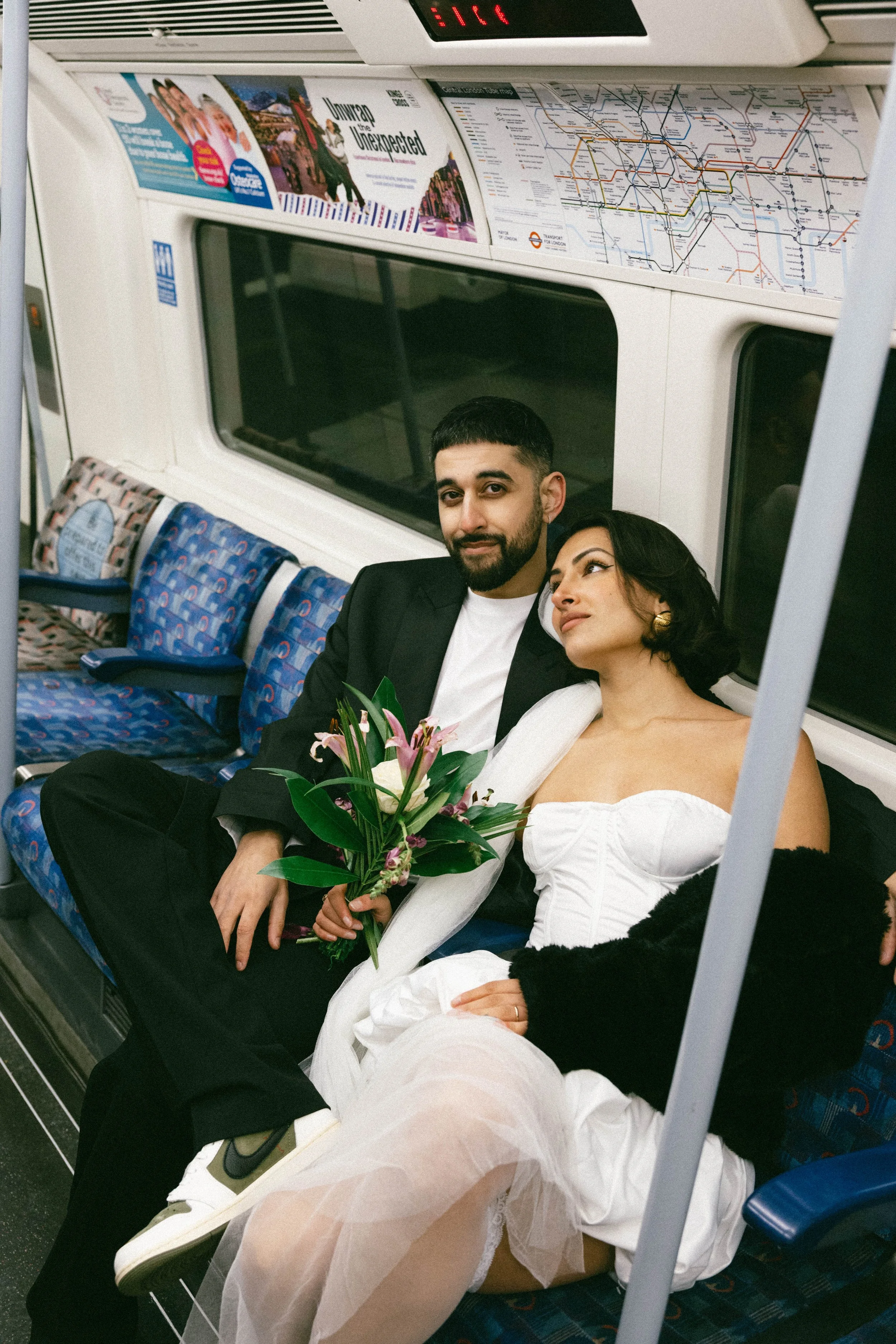 An intentional and relaxed moment of a bride and groom navigating the London Tube during their destination elopement