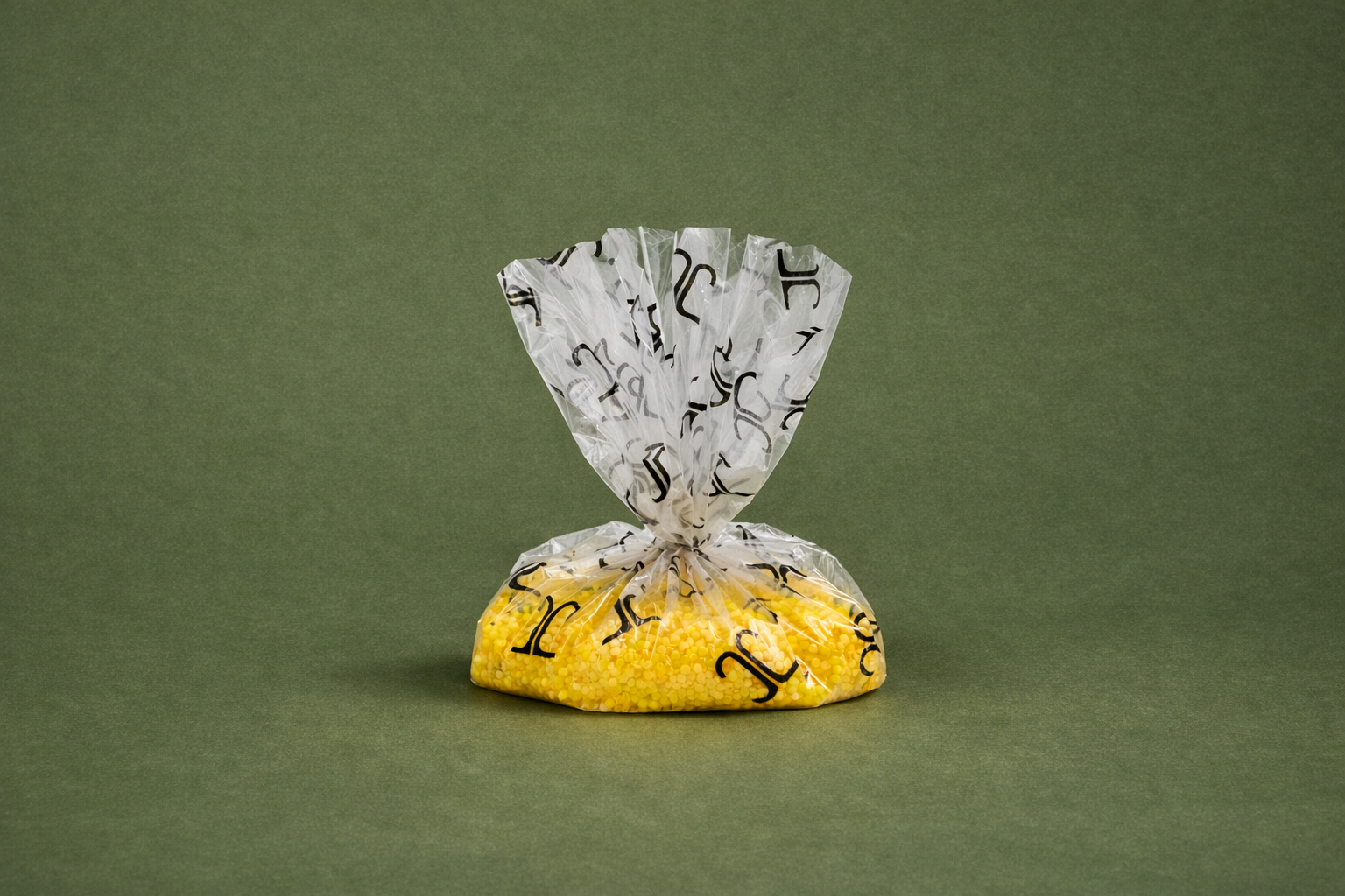 A clear plastic bag filled with yellow small round beads, twisted and sealed at the top.