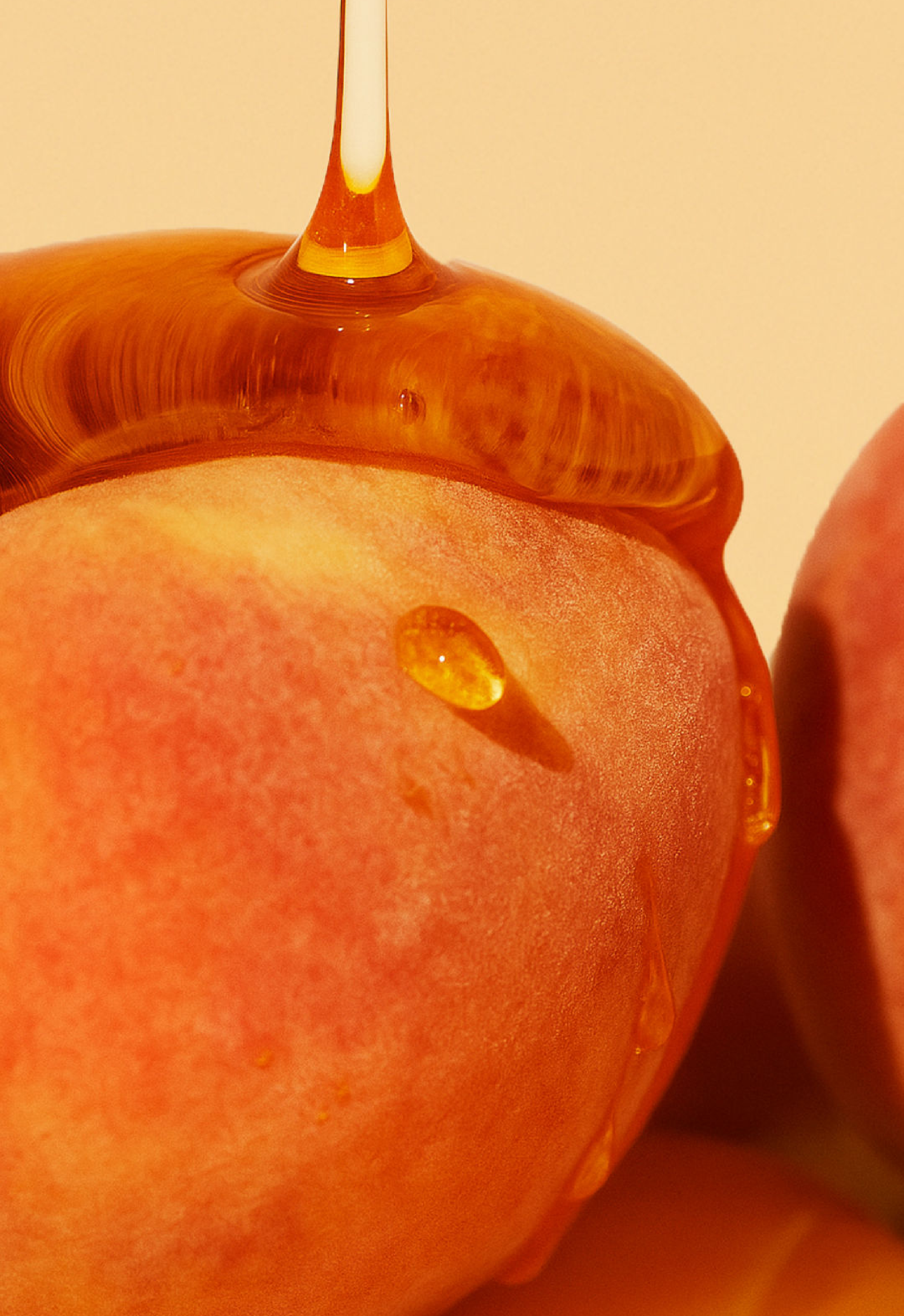Close-up of a peach with honey dripping on it.