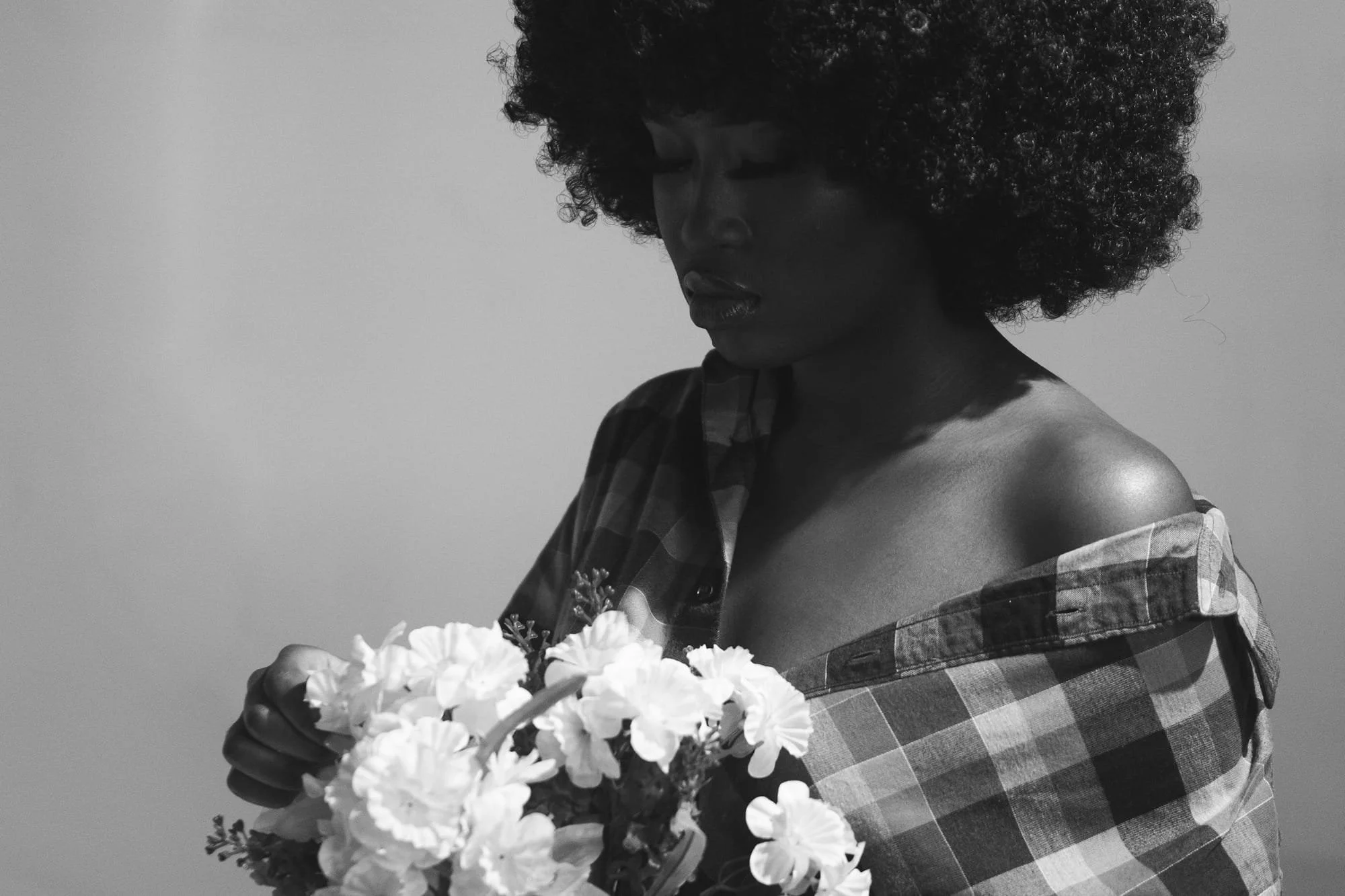 Woman looks at flowers with sadness after a domestic dispute