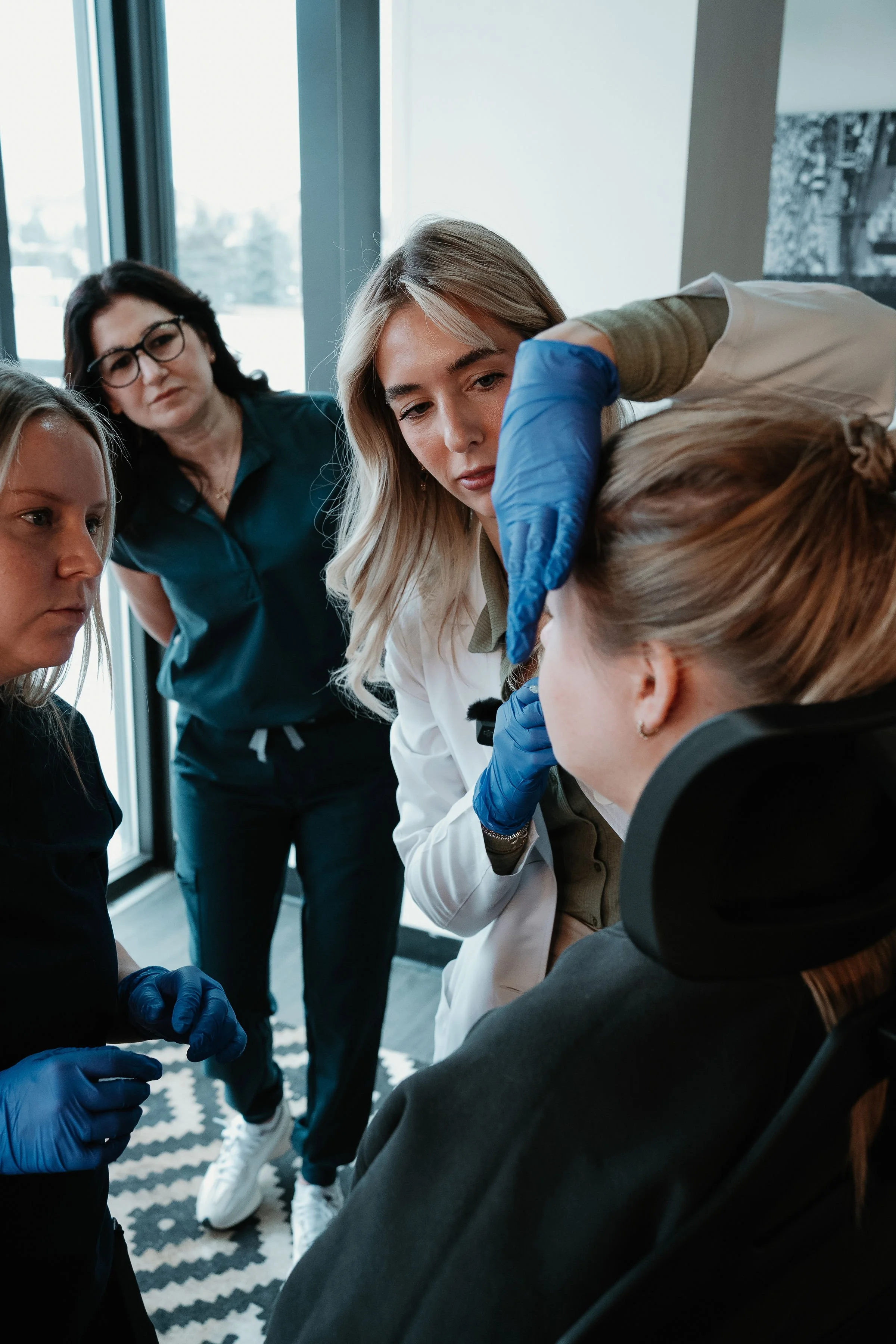 Medical professionals and a woman in a wheelchair during a consultation.
