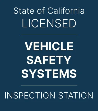 Sign for California Vehicle Safety Systems Inspection Station with white text on dark blue background.