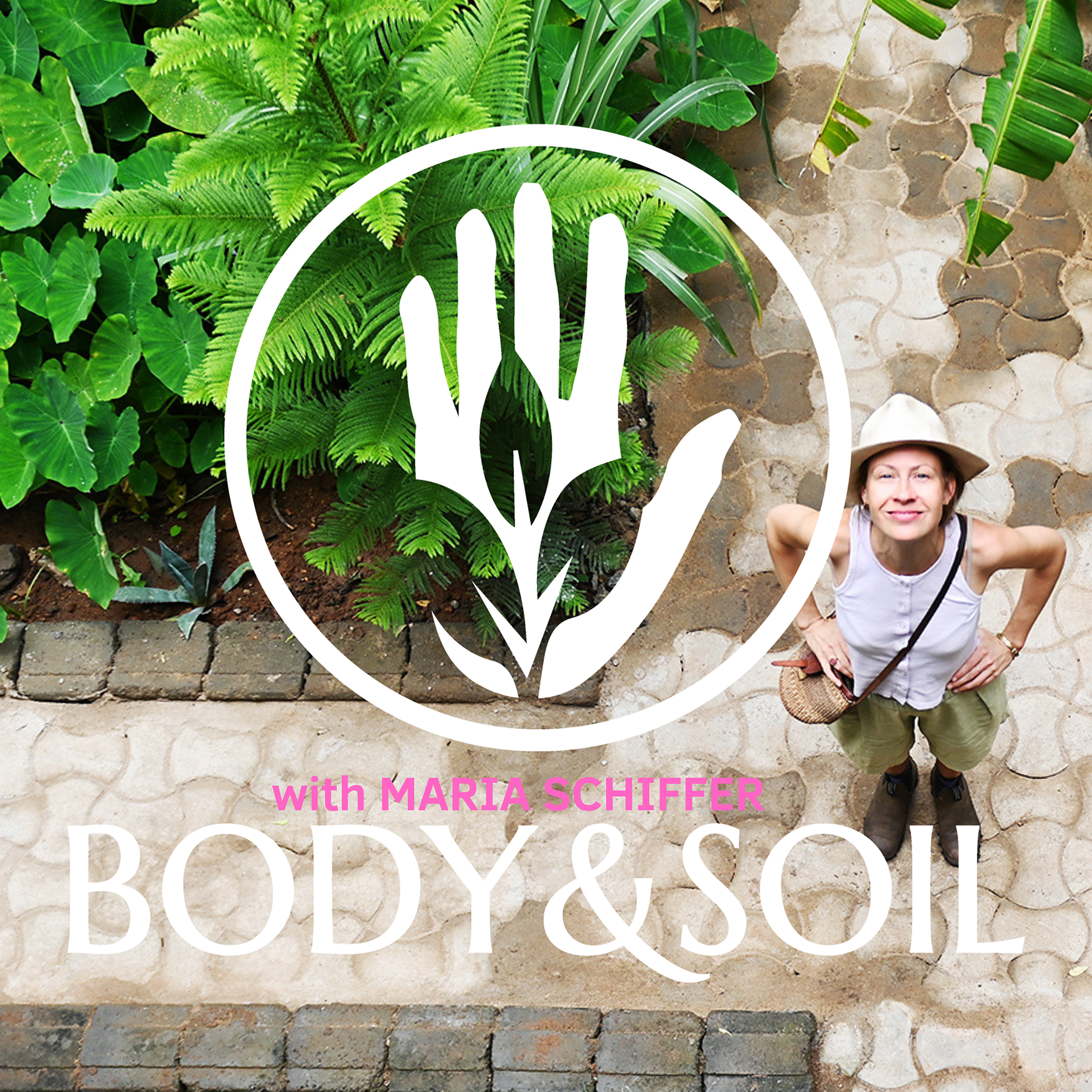 Ein Blick von unten auf eine Frau, die in einem Garten steht, von oben fotografiert. Die Frau trägt einen weißen Hut, ein weißes Top, khakifarbene Shorts und schwarze Schuhe. Der Garten ist mit grünen Pflanzen, darunter Farn und große Blattpflanzen, gestaltet. Ein Logo mit einer weißen Hand in einem Kreis liegt über dem Bild, zusammen mit dem Text "with MARIA SCHIFFER BODY & SOIL" in Pink und Weiß.