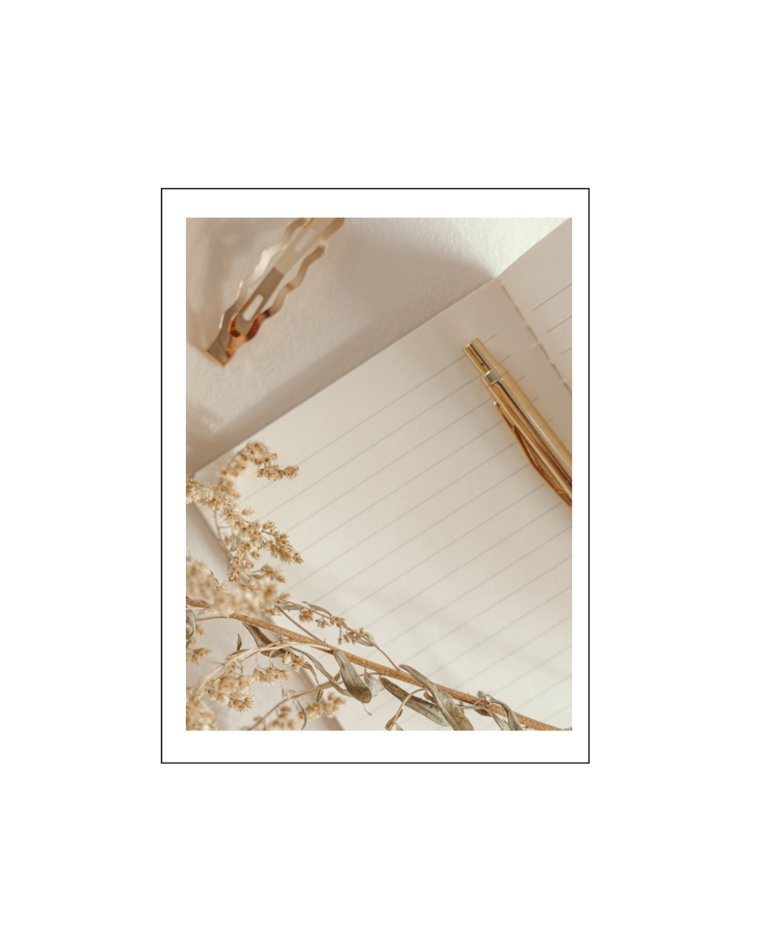 Open notebook with lined pages, gold pen, dried flowers, and a metallic hair clip on a white surface. Business systems documentation and strategic planning workflow