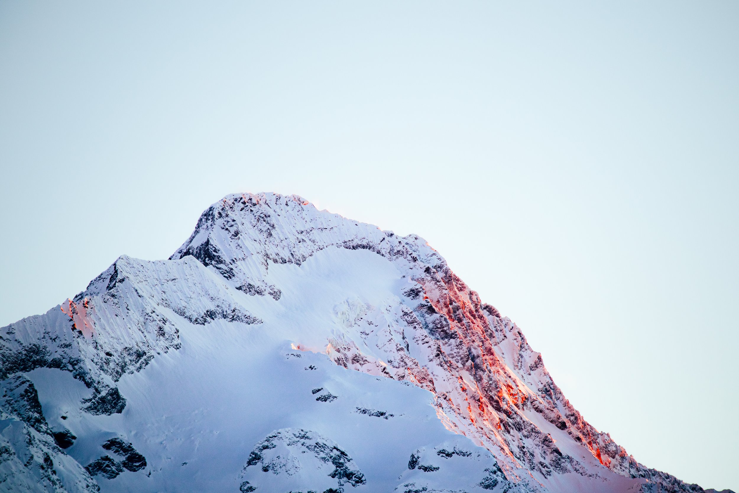 Sommet d'une montagne enneigée avec un ciel clair