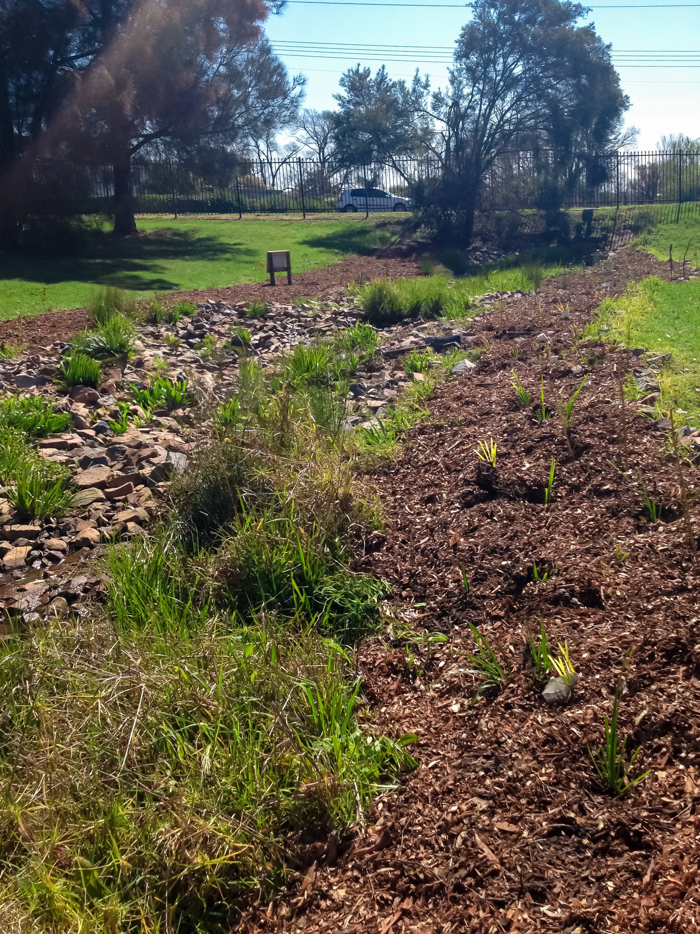 A drainage swale with rock channel and grading to control runoff and erosion for outdoor living areas in Brandywine, MD