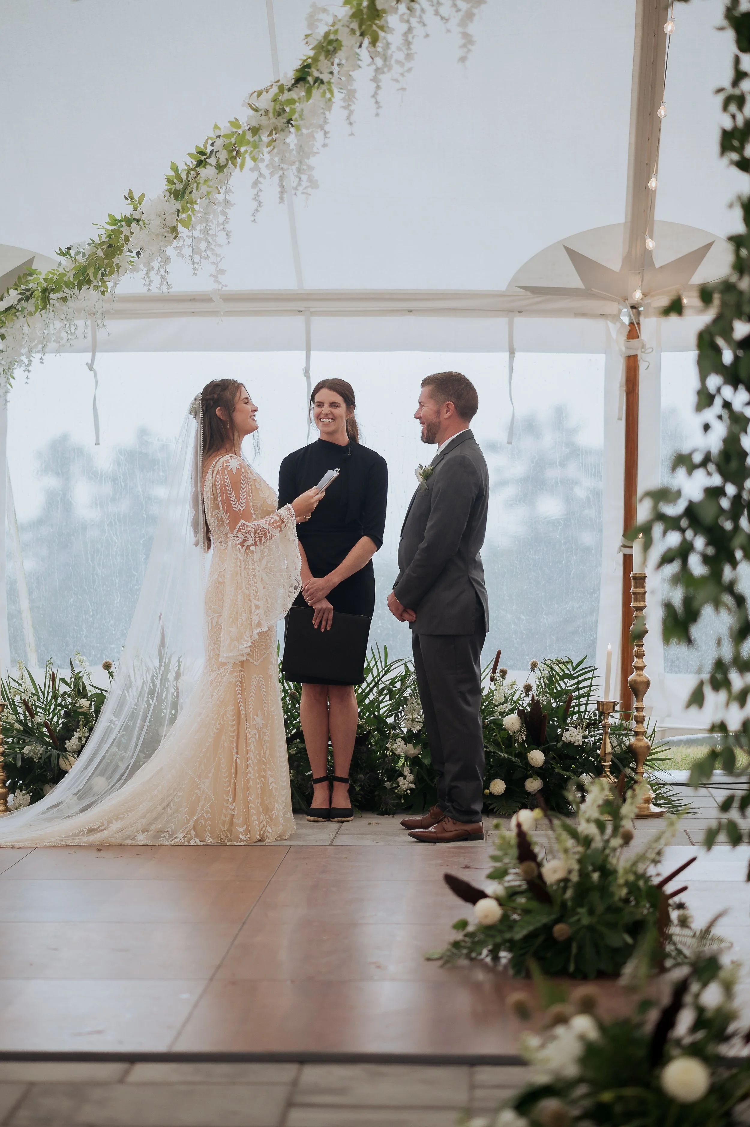 Officiant guiding vows during an intimate tented wedding ceremony in New England