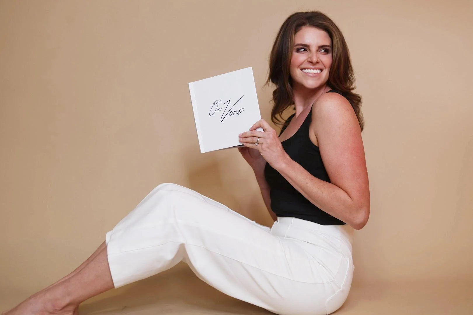 Wedding officiant Chelsea of The Marrying Jane holding a vow book, representing ceremony coaching and vow guidance for couples