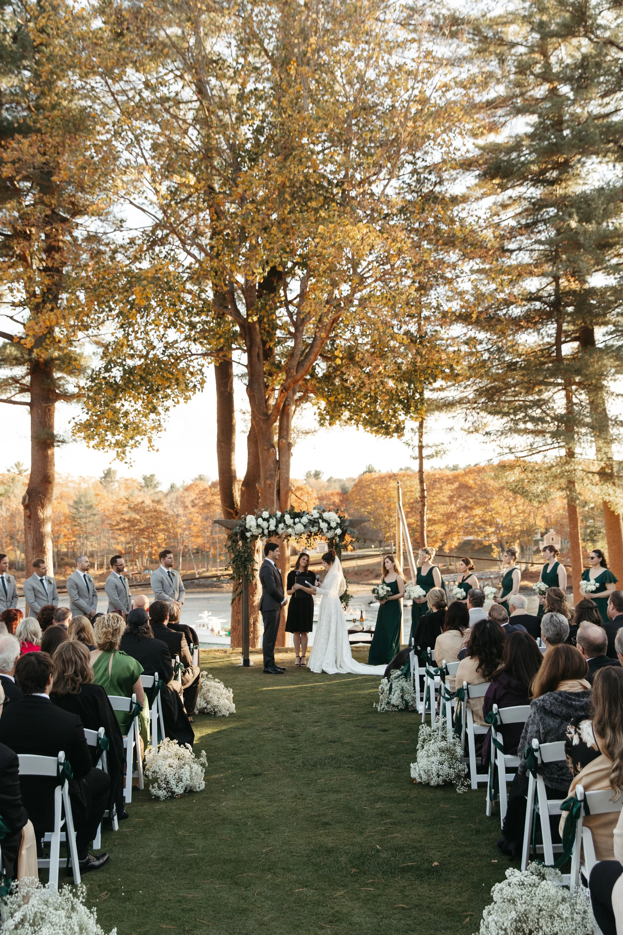 Wedding officiant leading Madi and Steve’s multicultural ceremony at York Golf and Tennis Club in York, Maine, featuring Jewish and Greek traditions beneath a chuppah
