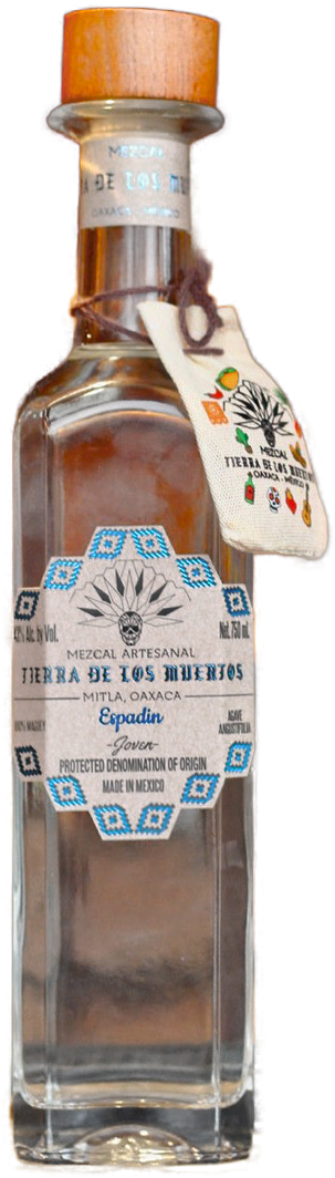 A clear glass bottle of Mezcal with a wooden stopper, labeled Tierra de Los Muertos, from Oaxaca, Mexico, with a decorative tag and a woven cloth around the neck.