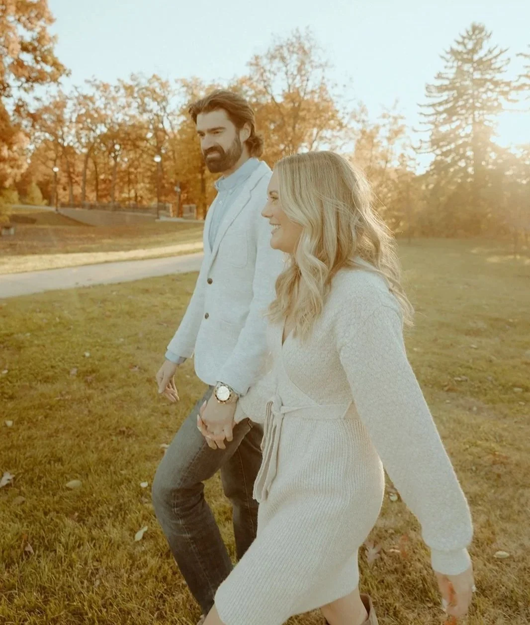 Owners at Guided Growth walking hand in hand outdoors during autumn, with trees and sunlight in the background. They offer parent coaching nationwide for AAC and GLP.
