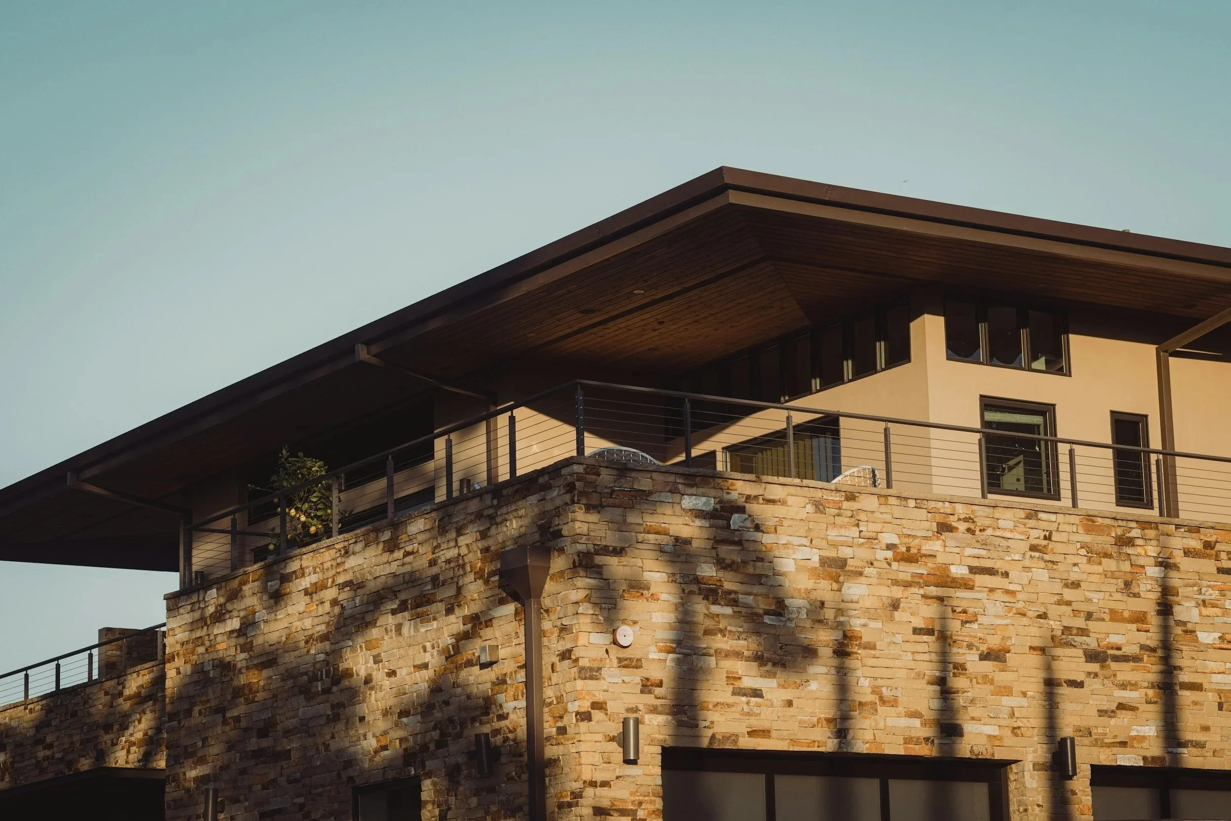 Modern multi-level house with large clean windows and clear gutter system, in the late afternoon sunlight.