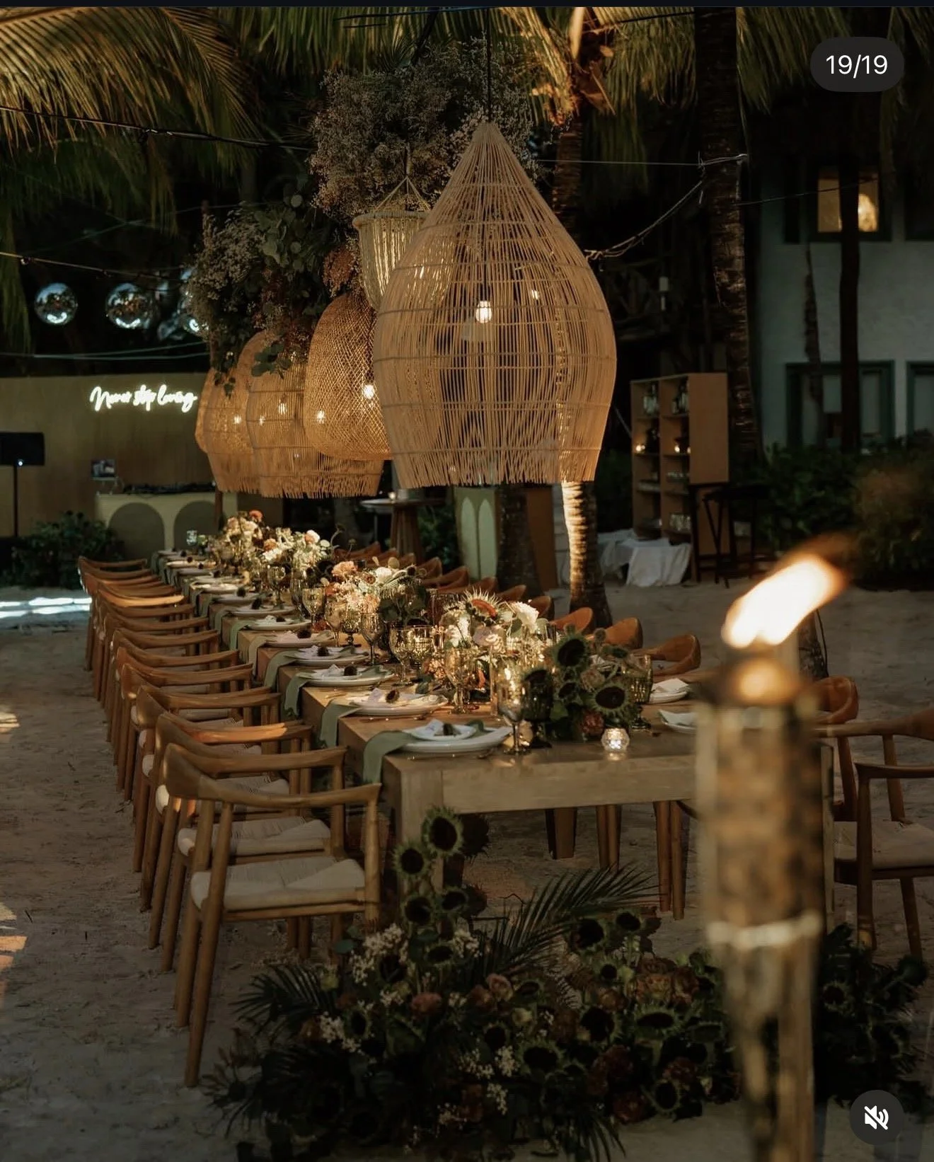 Elegant outdoor wedding reception in Holbox with floral centerpieces, candles, and tropical surroundings.