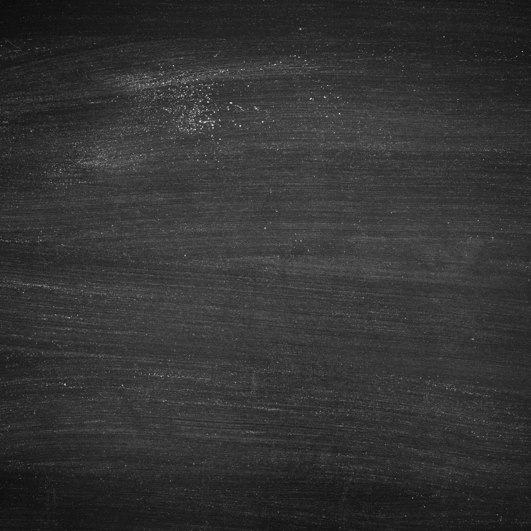 Black chalkboard with scattered white chalk dust and streaks from erased writing.