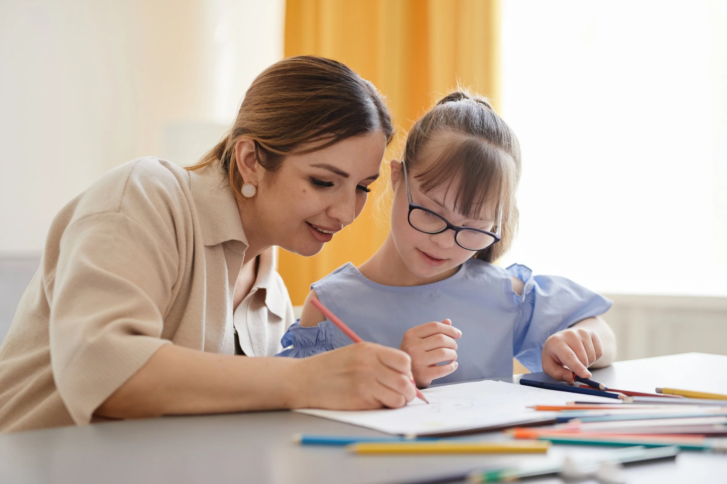 A care provider assisting an adolescent with an activity