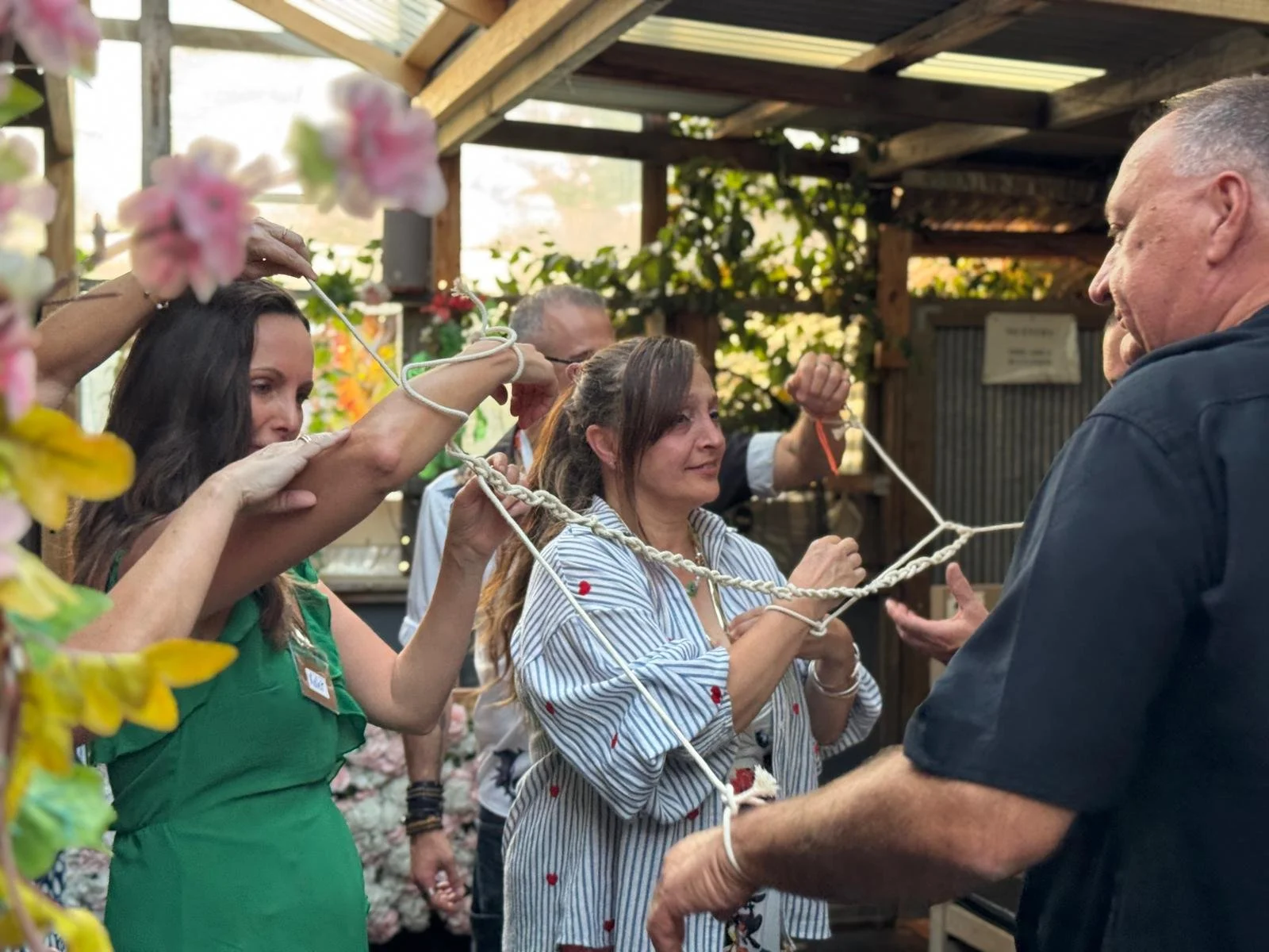 Group of four friends enjoying food and drinks at a bar or restaurant, smiling and laughing together.
