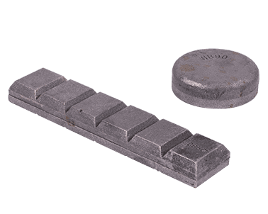 Kaksi suurempaa ja russakampaa kiveä, yksi suorakaiteen muotoinen ja toinen pyöreä.