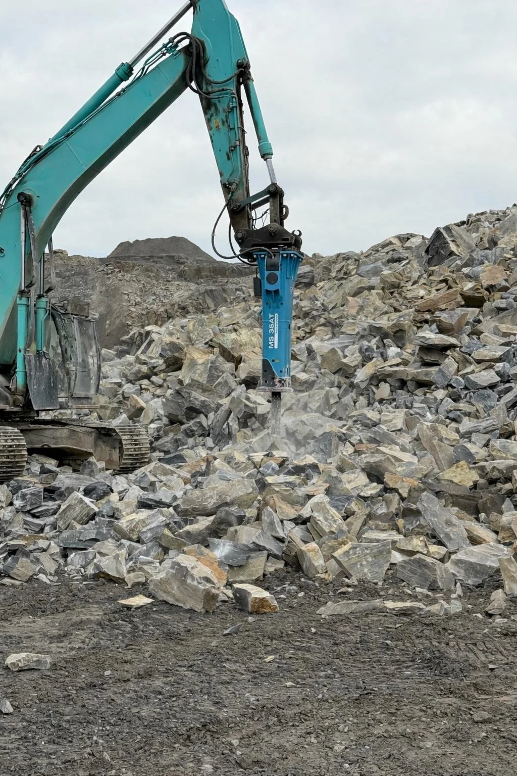 Kaivinkone poraa kiveä maasta rakennustyömaalla