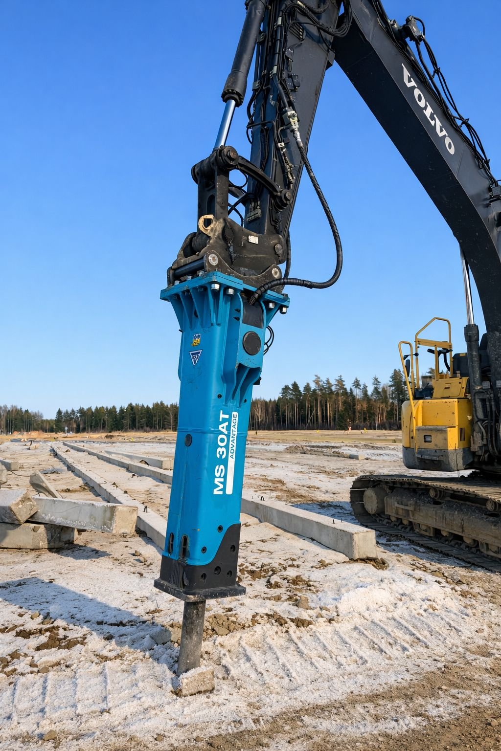 Rakennustyömaa, jossa on kaivinkone ja rakennustelineitä, ja taivaalla on selkeä sininen taivas.