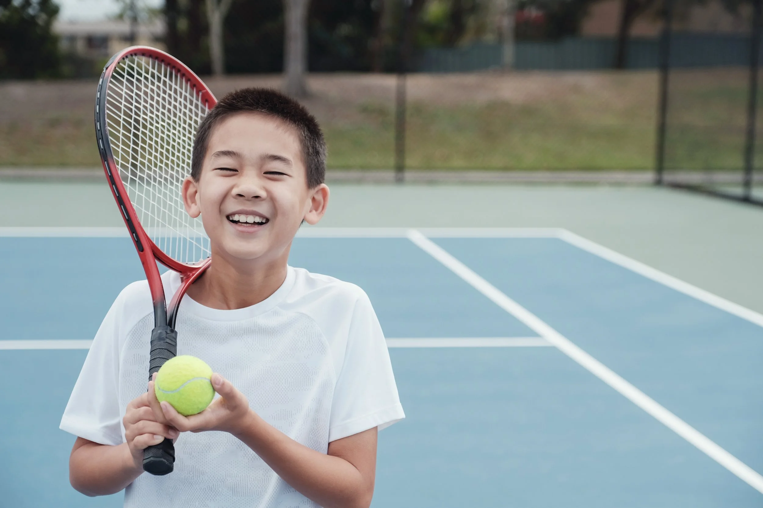 Young boy on court with tennis racquet